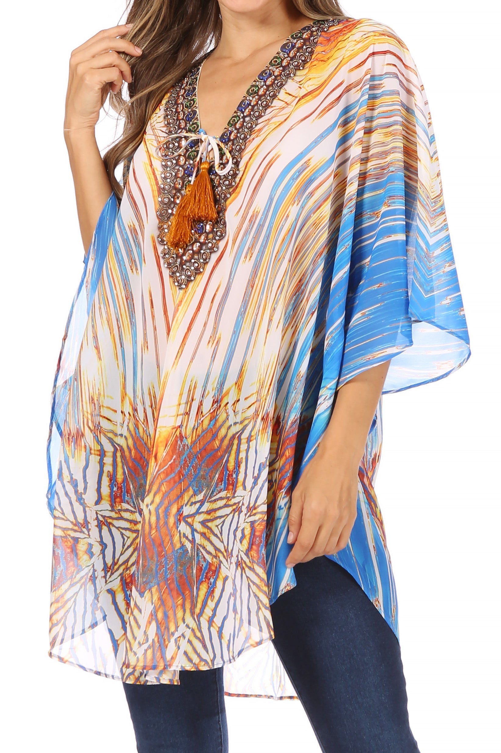 Colorful patterned top with tassel detail worn by a model on a white background