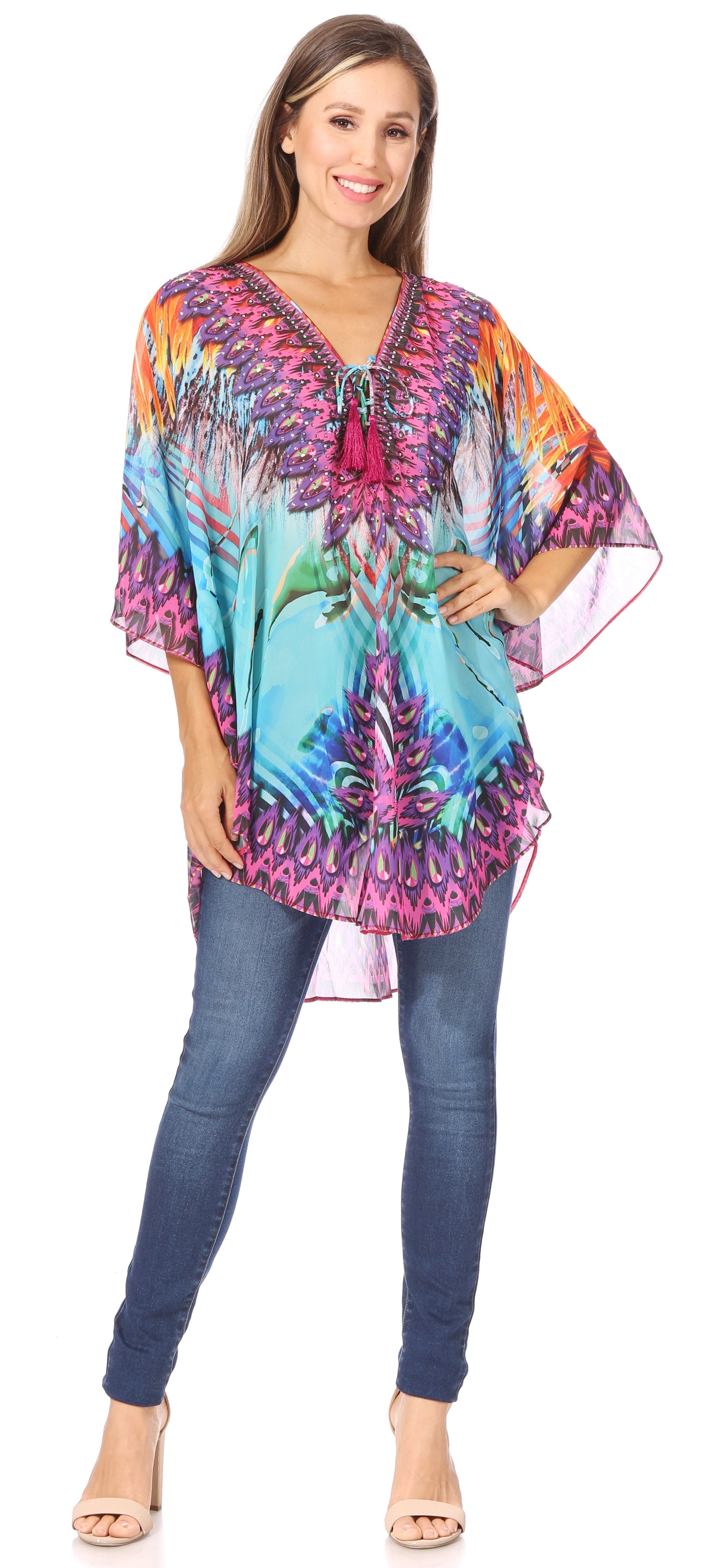 Woman wearing a colorful patterned top and jeans on a white background