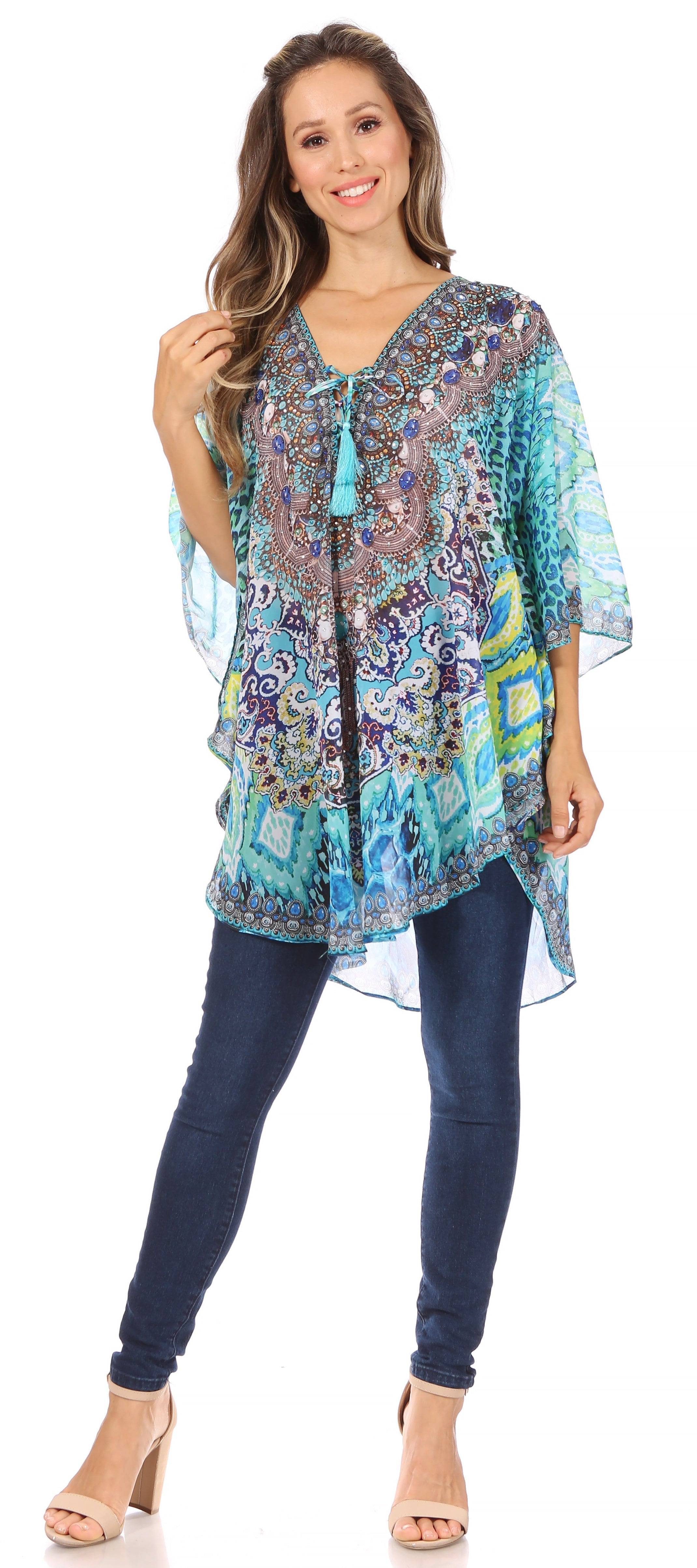 Woman wearing a colorful patterned top and blue jeans on a white background