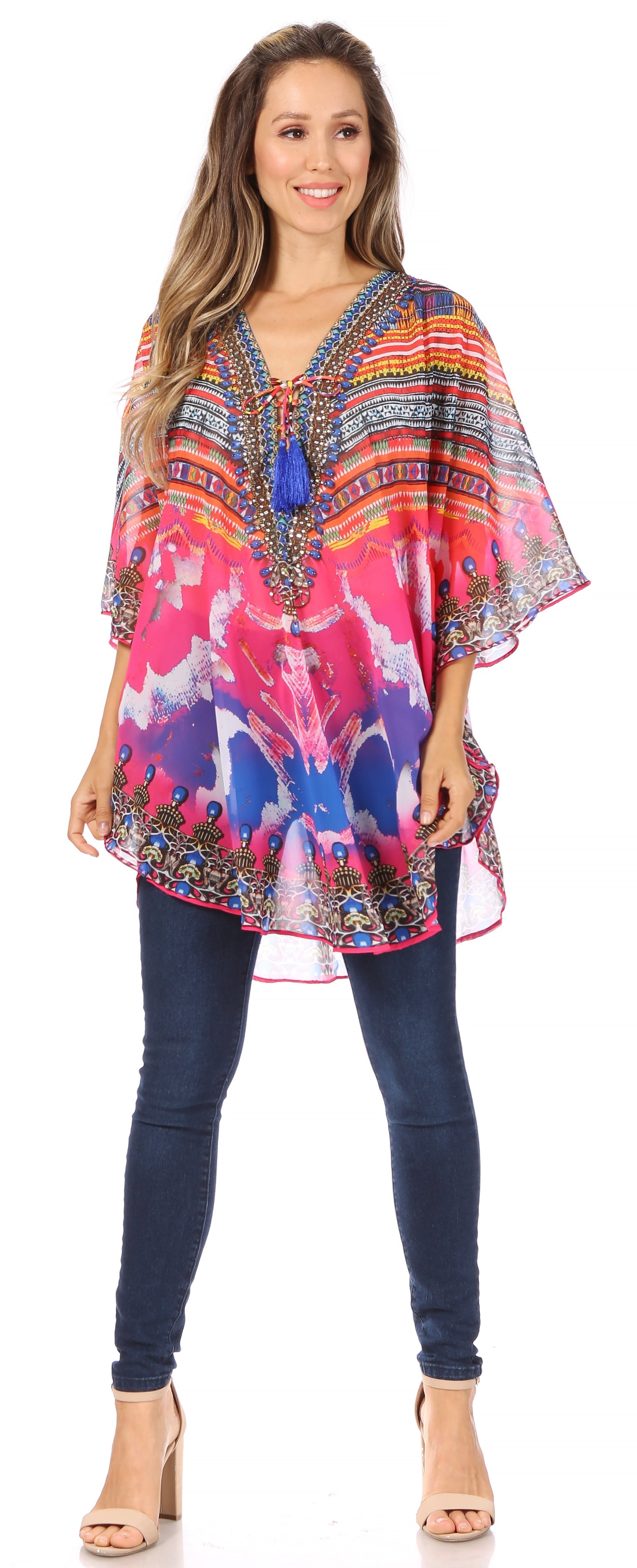 Woman wearing a colorful patterned top and blue jeans on a white background