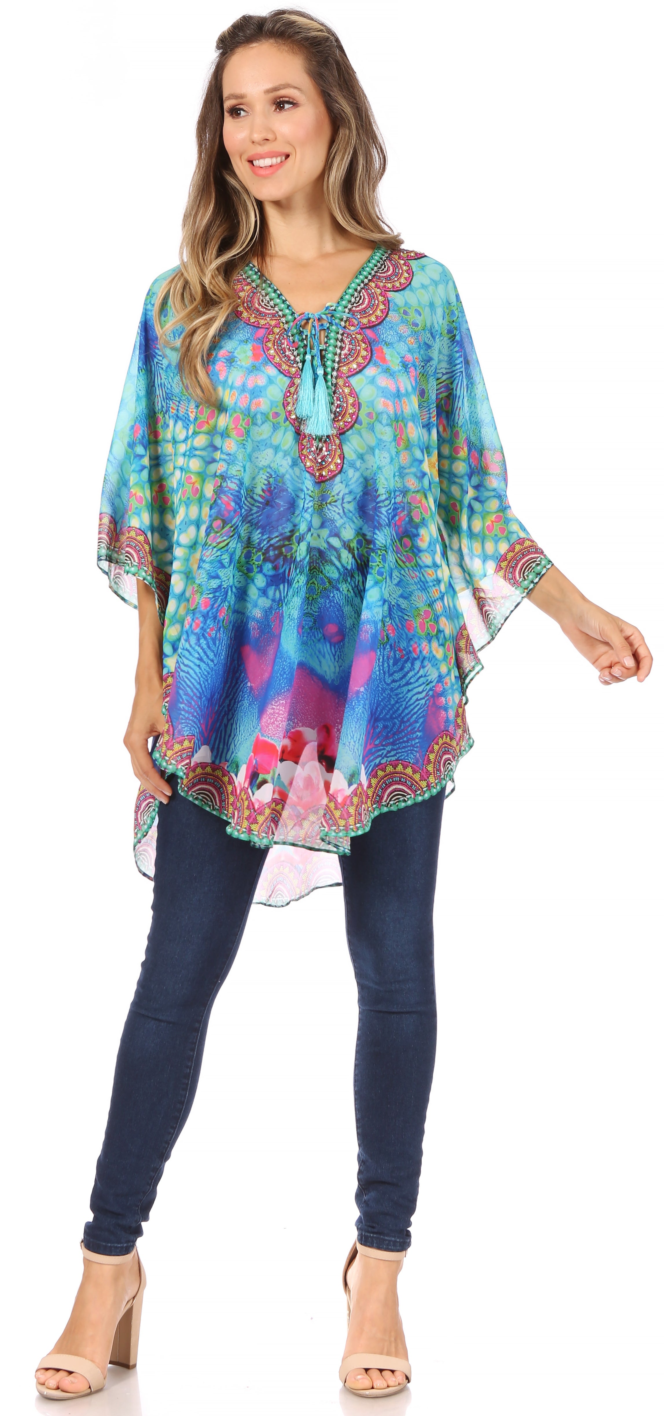 Woman wearing a colorful patterned top and blue jeans on a white background