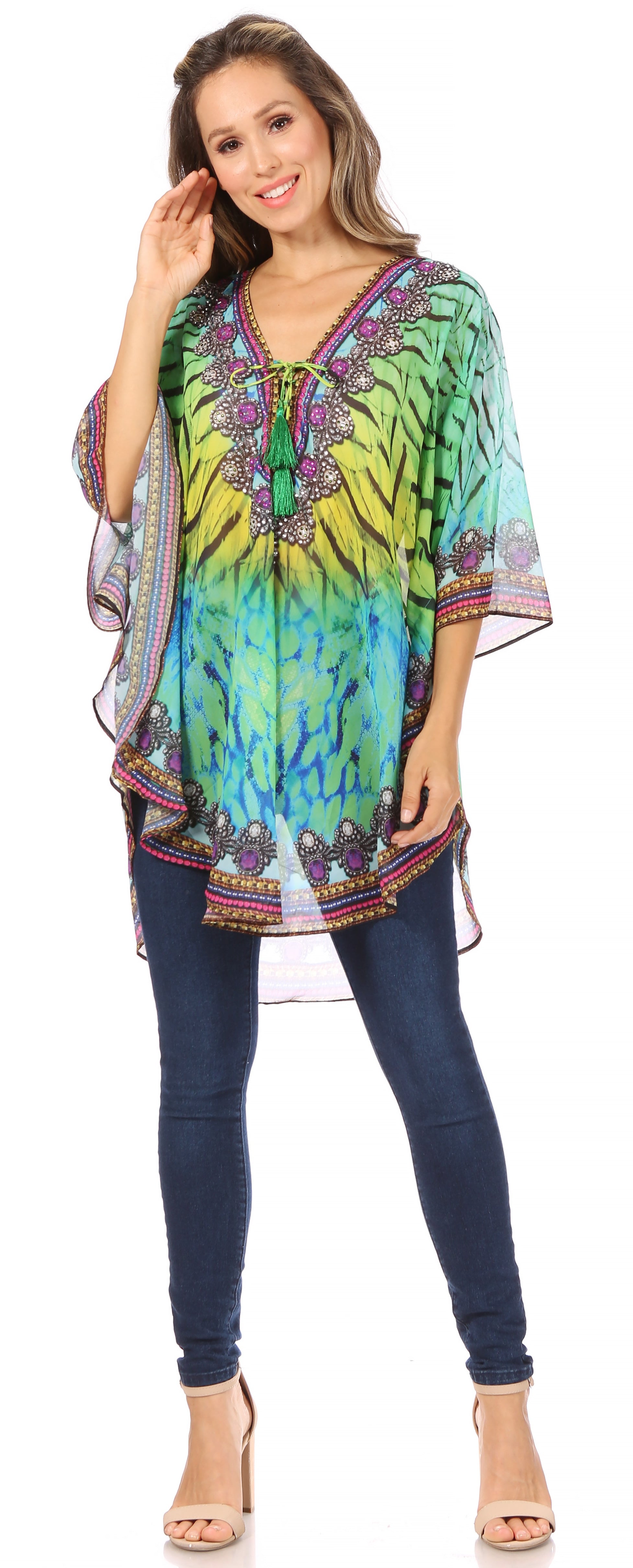 Woman wearing a colorful tie-dye top with a pattern and blue jeans on a white background