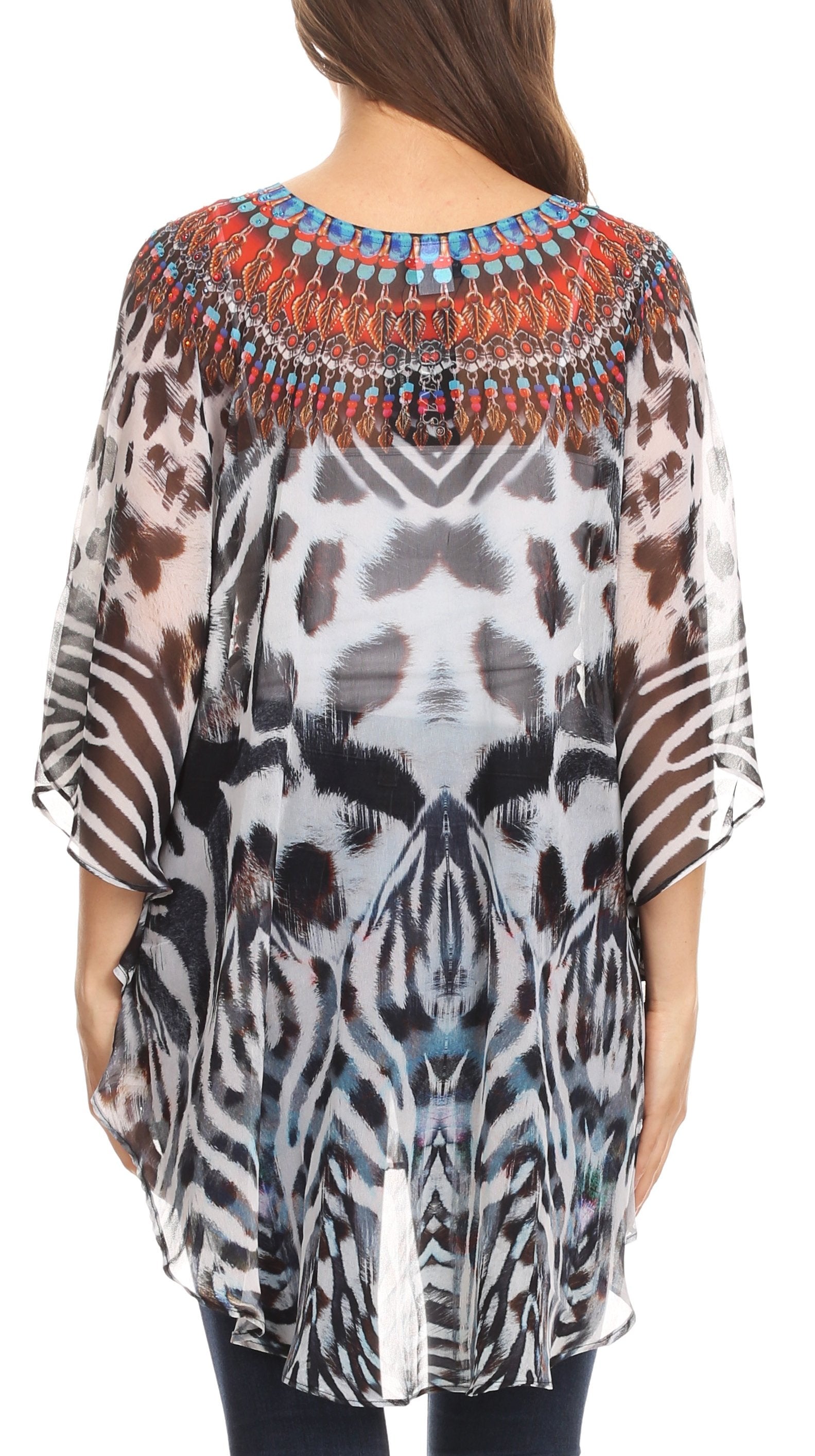 Woman wearing a patterned sheer top with embellishments on a white background