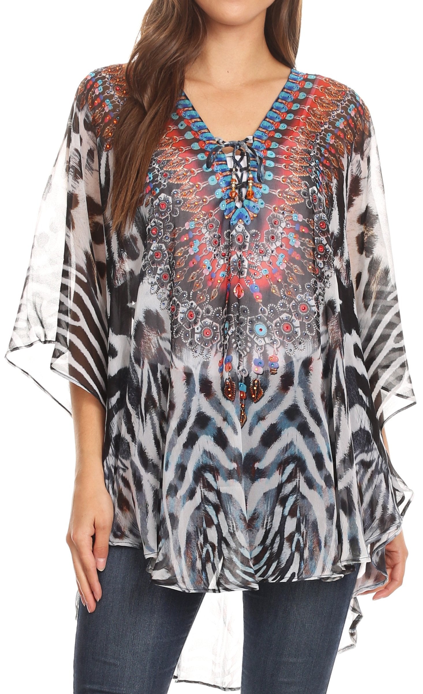 Woman wearing a patterned blouse with zebra print and colorful embellishments.