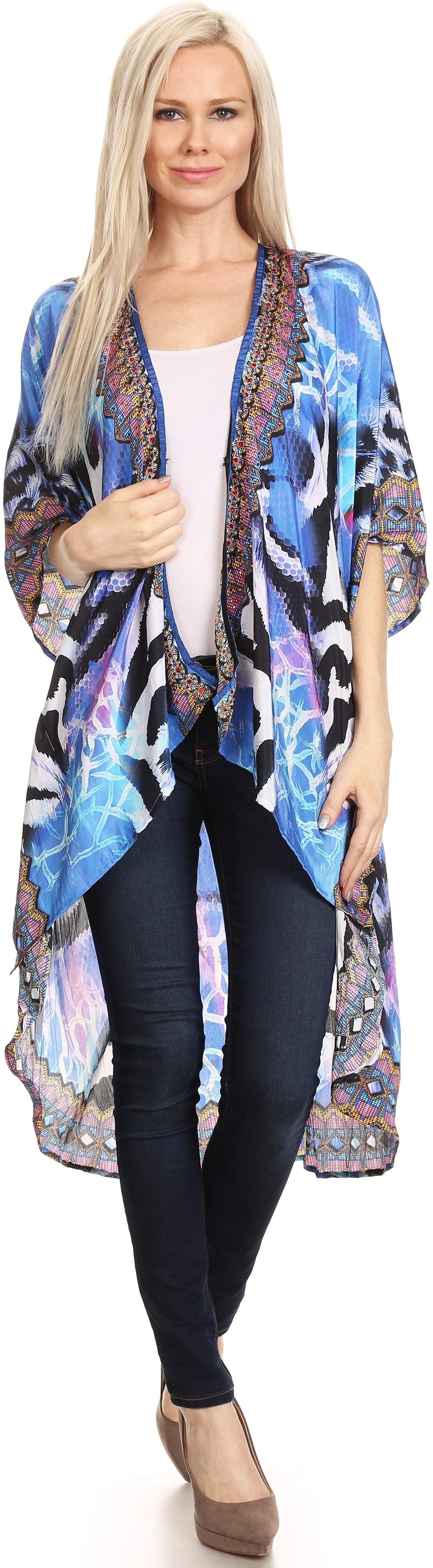 Woman wearing a colorful kimono-style jacket over a white top and black pants on a white background