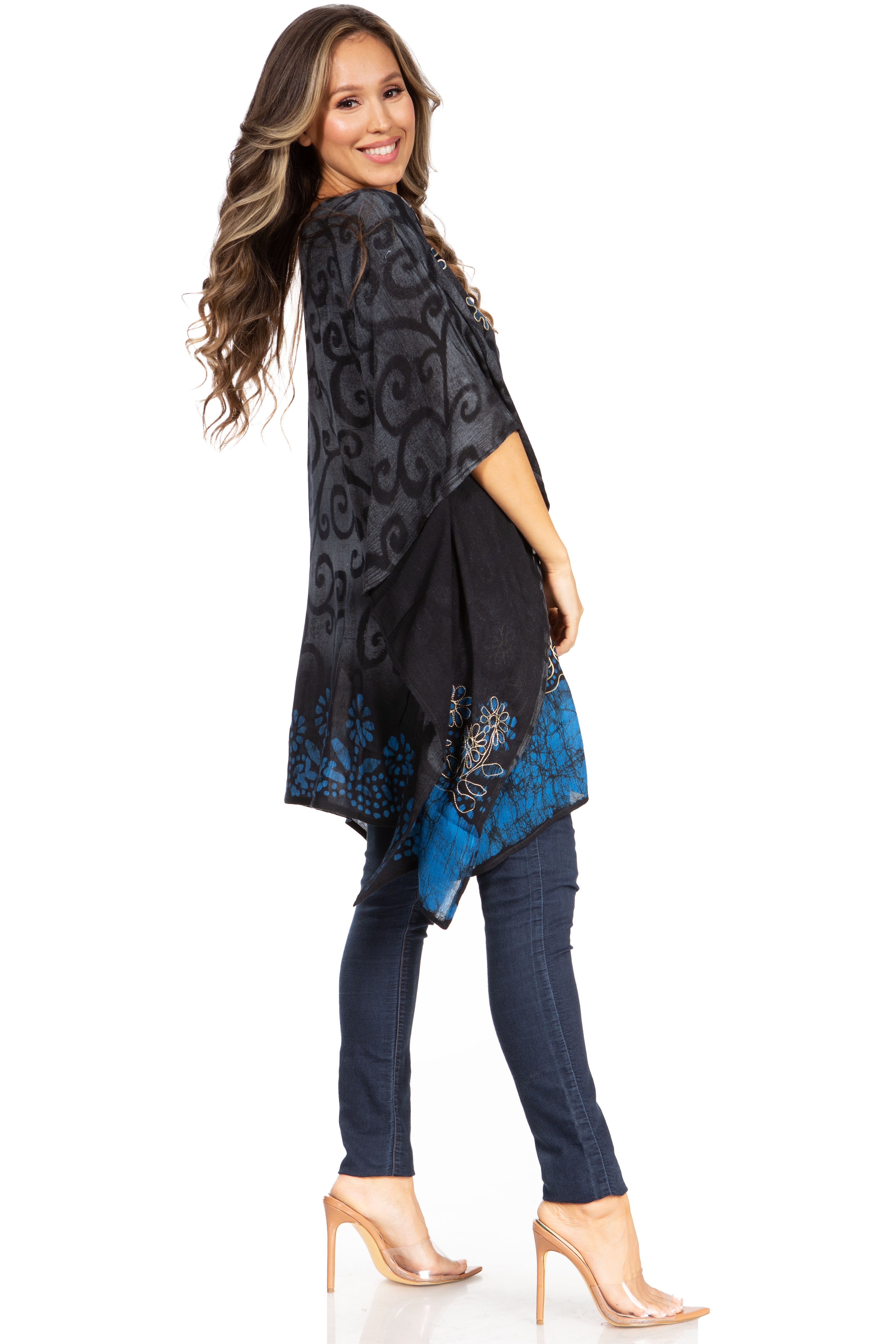 Woman wearing a black and blue patterned dress with jeans on a white background
