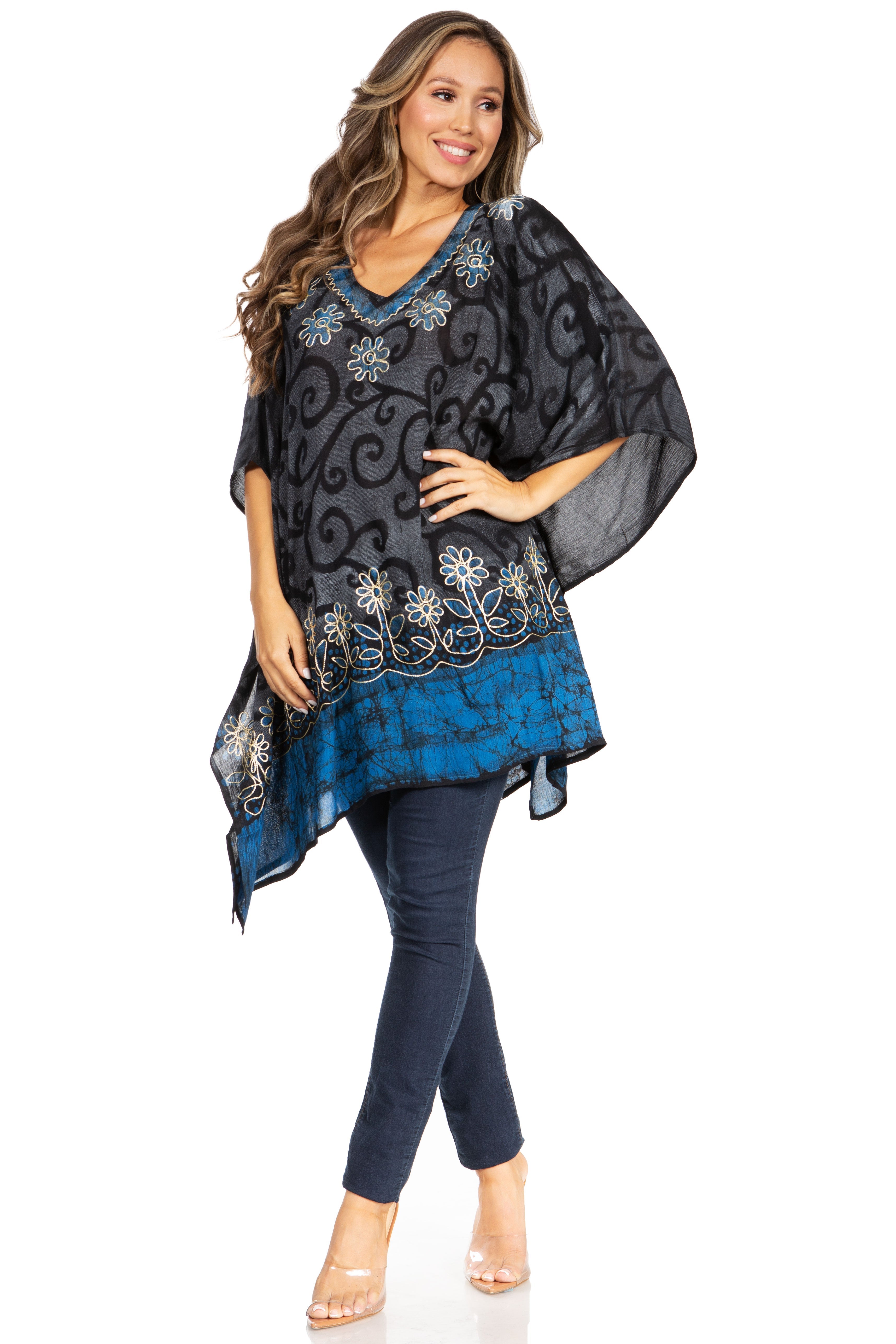Woman wearing a black and blue patterned top with dark jeans on a white background