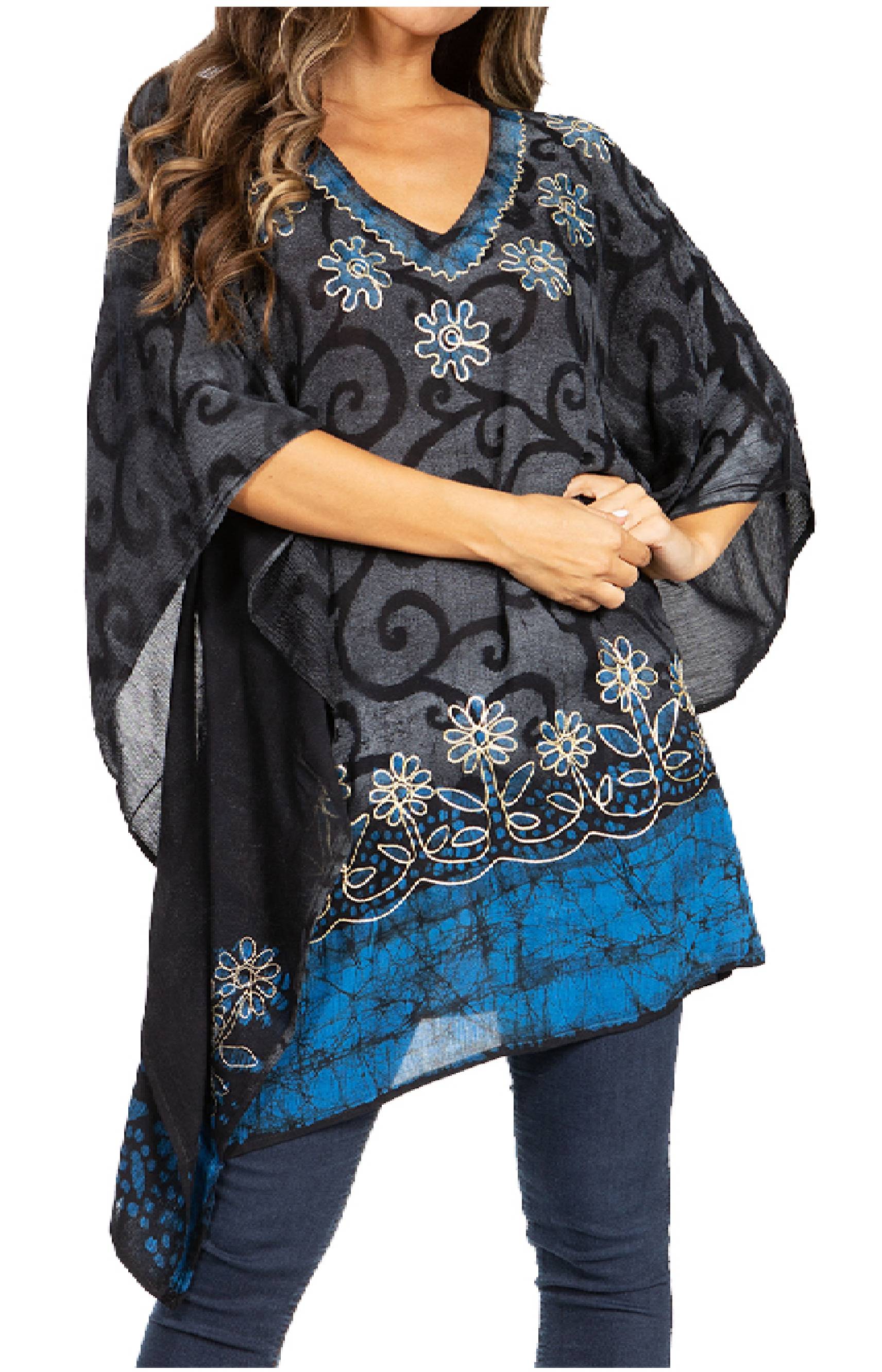 Woman wearing a dark gray and blue patterned poncho with floral designs.