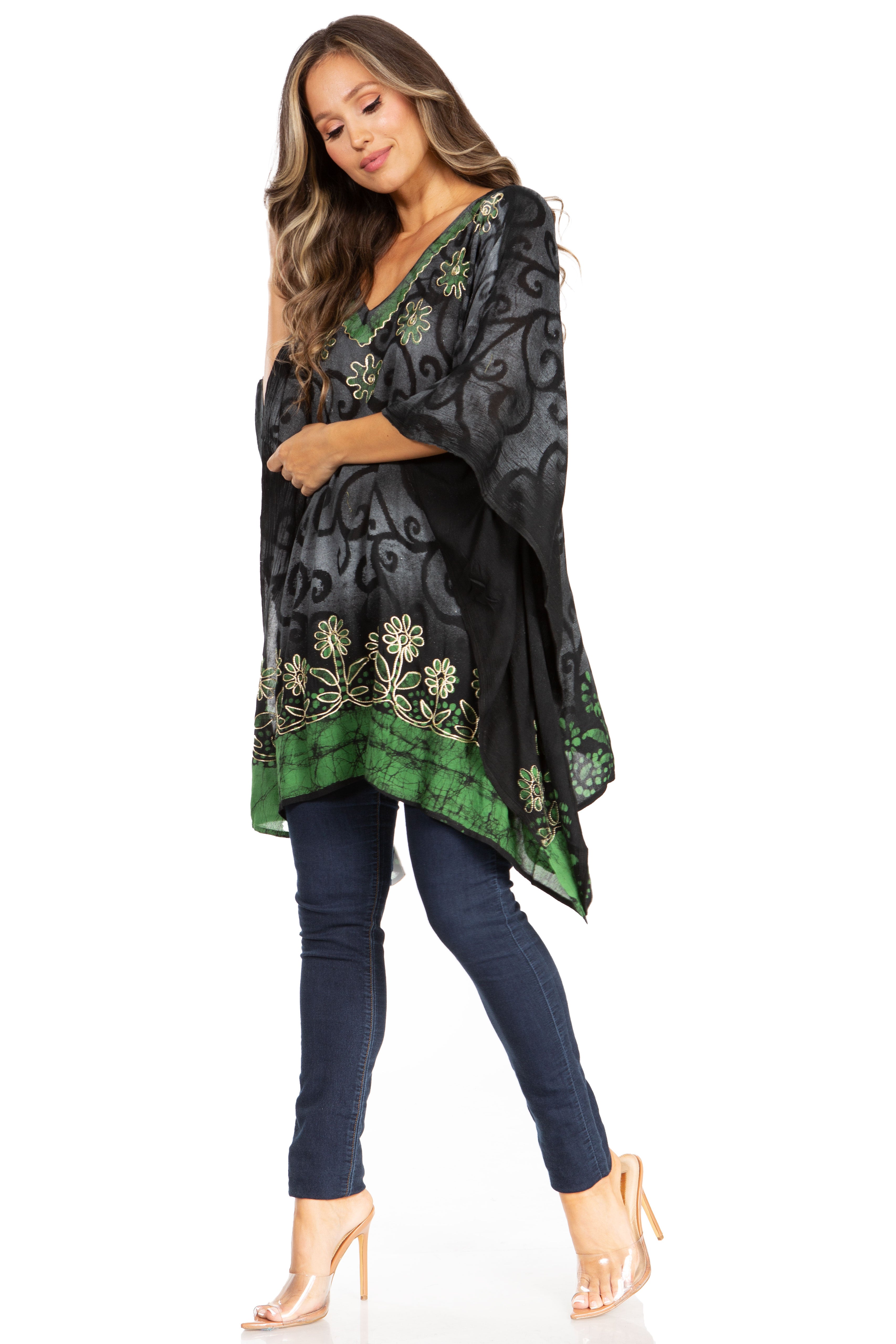 Woman wearing a black and green patterned top with blue jeans on a white background