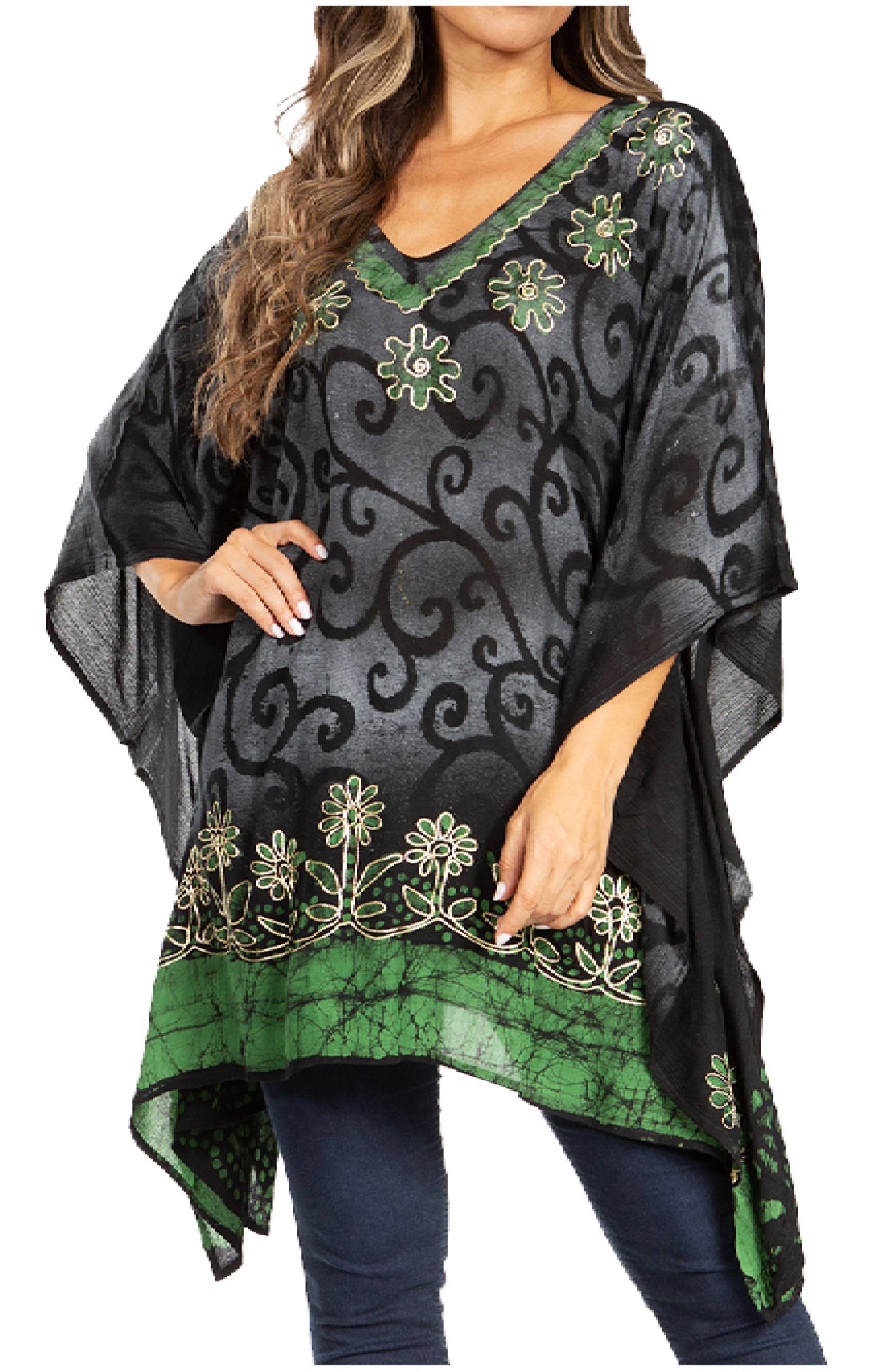 Woman wearing a black and green patterned poncho with floral embellishments.