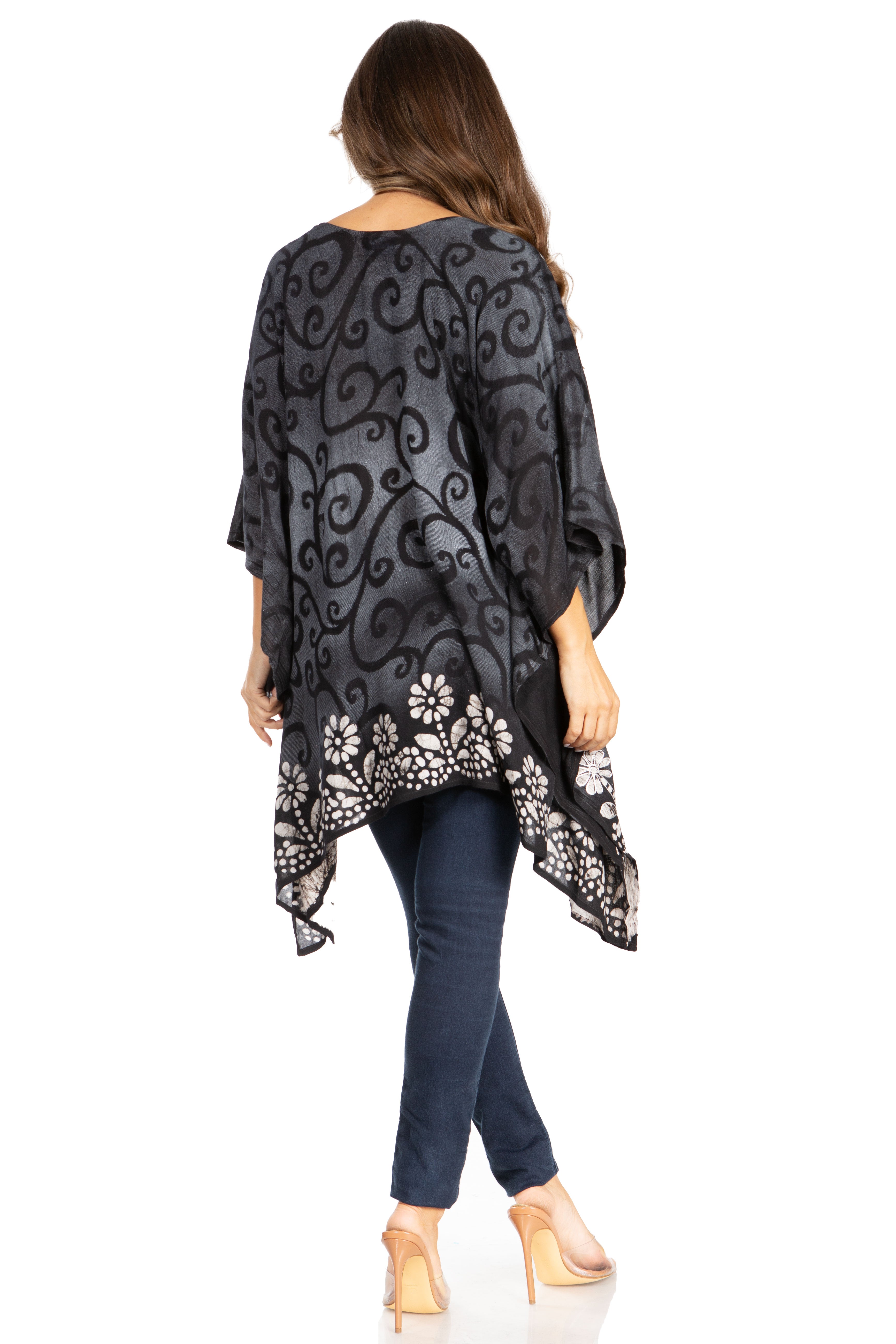 Woman wearing a black floral patterned kimono over a dark top and jeans on a white background