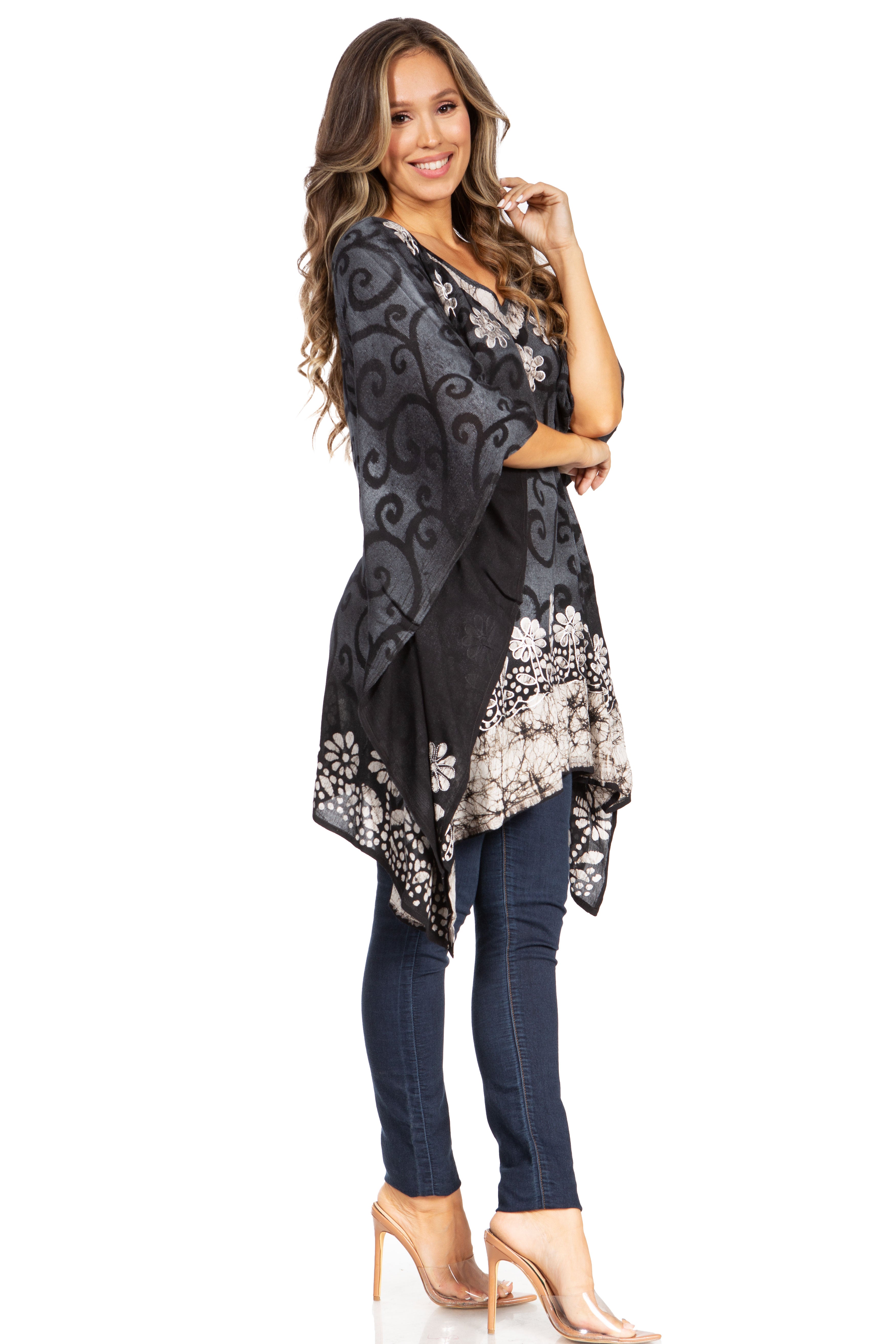 Woman wearing a black floral patterned top and jeans on a white background