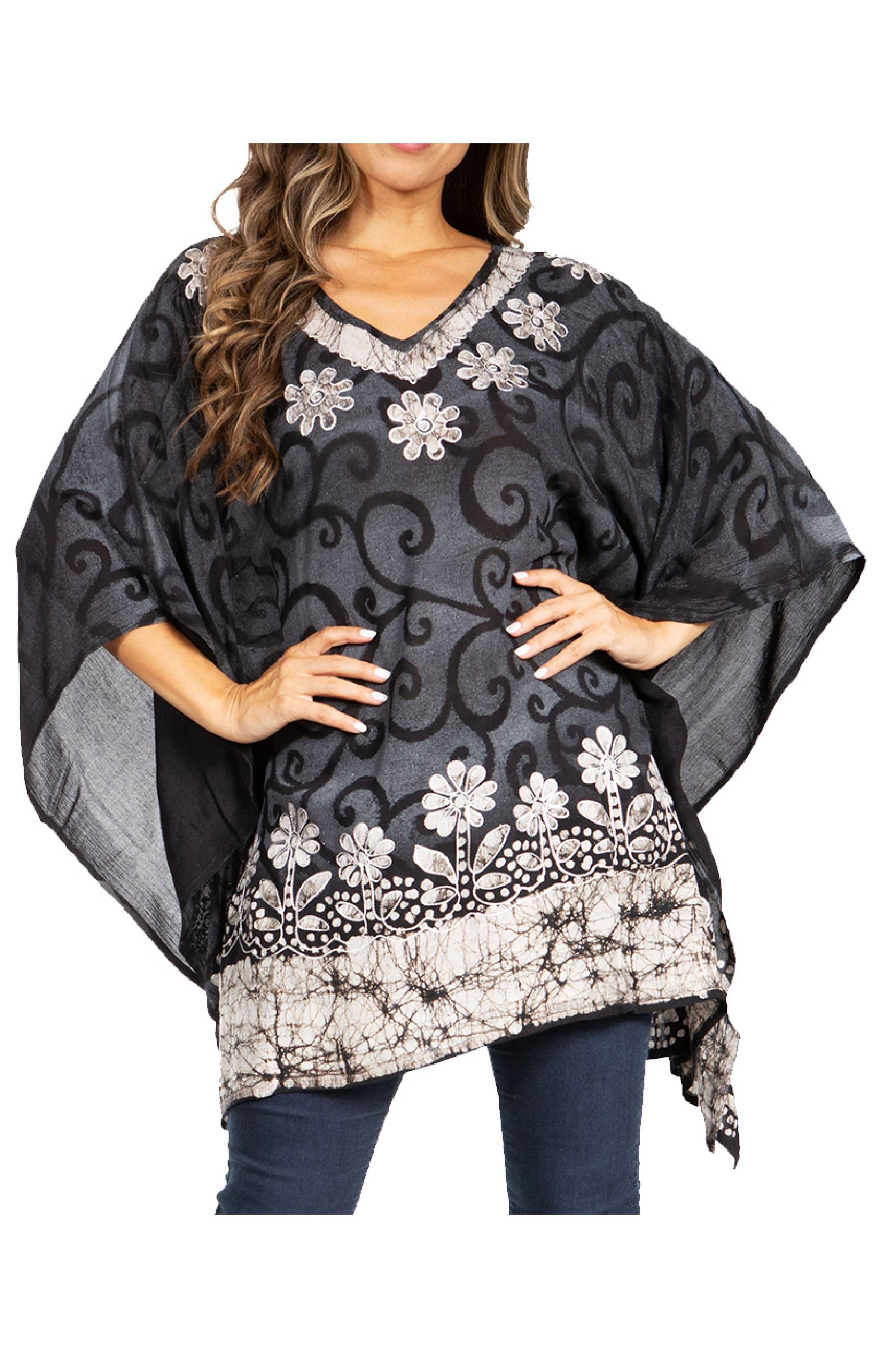 Woman wearing a black and gray patterned poncho with floral embellishments on a white background