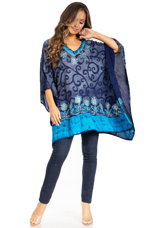 Woman wearing a blue and navy embroidered top with matching pants on a white background