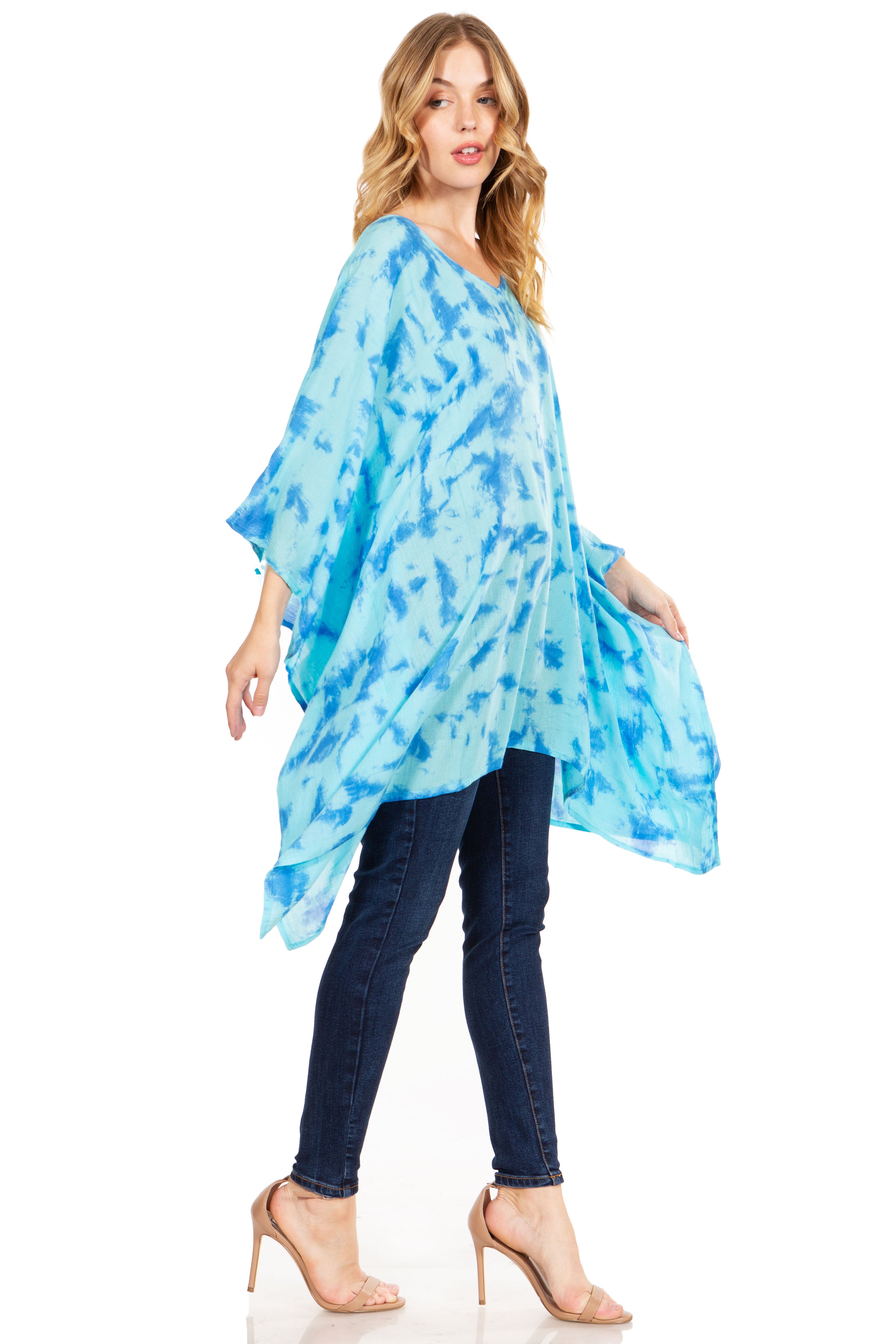Woman wearing a blue tie-dye poncho over a white background
