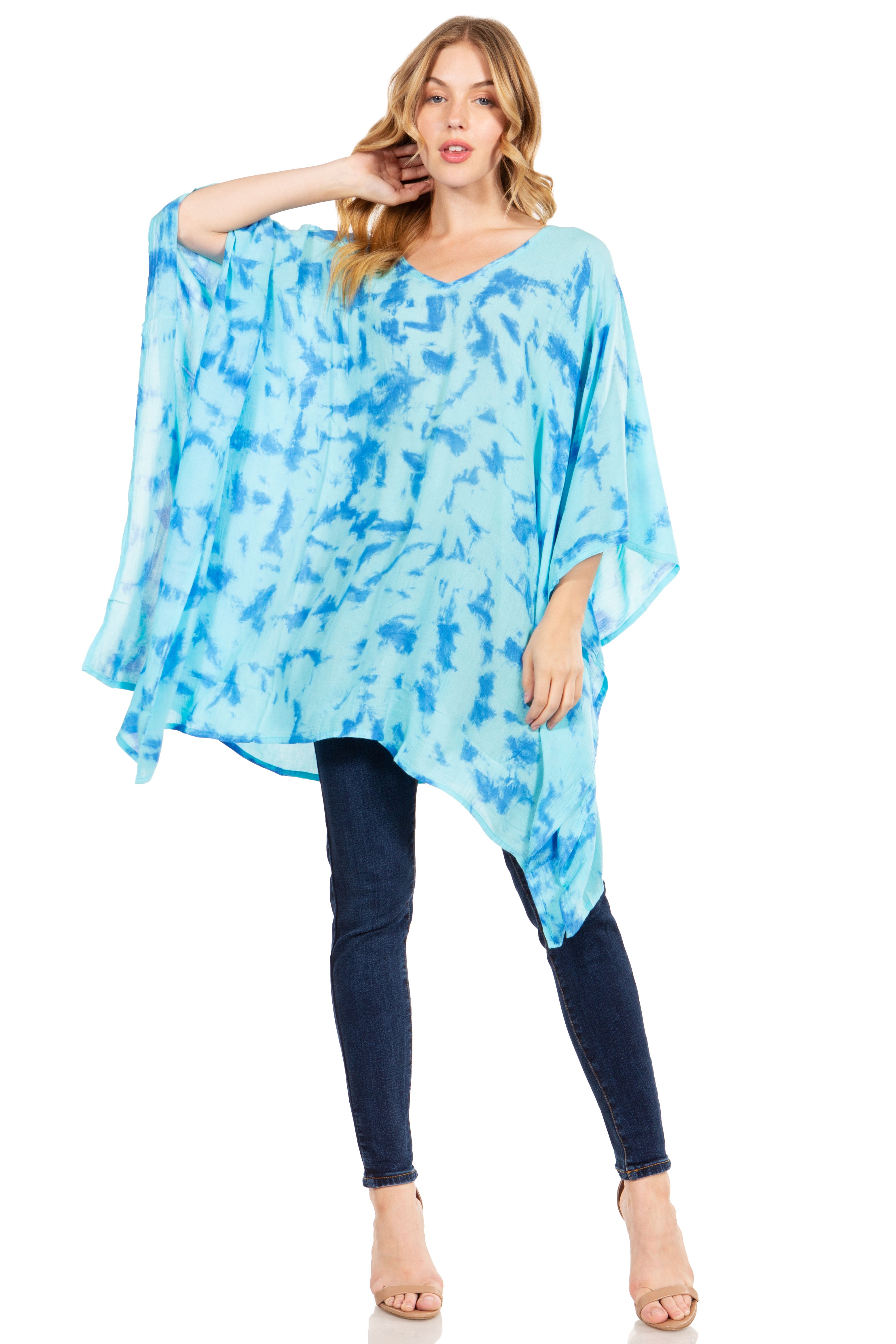 Woman wearing a blue tie-dye poncho over a plain background