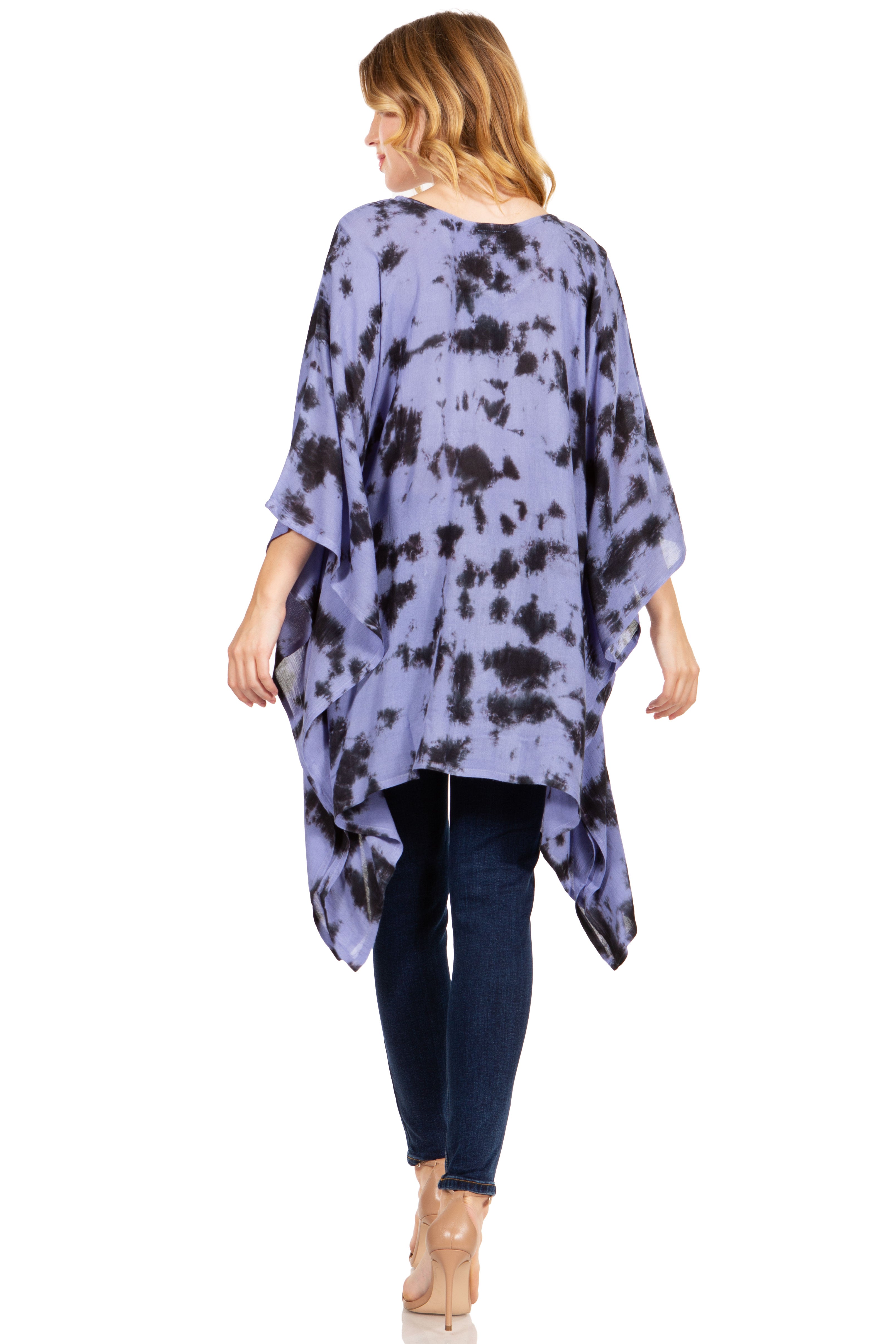 Woman wearing a purple tie-dye kimono over a black top and blue jeans on a white background