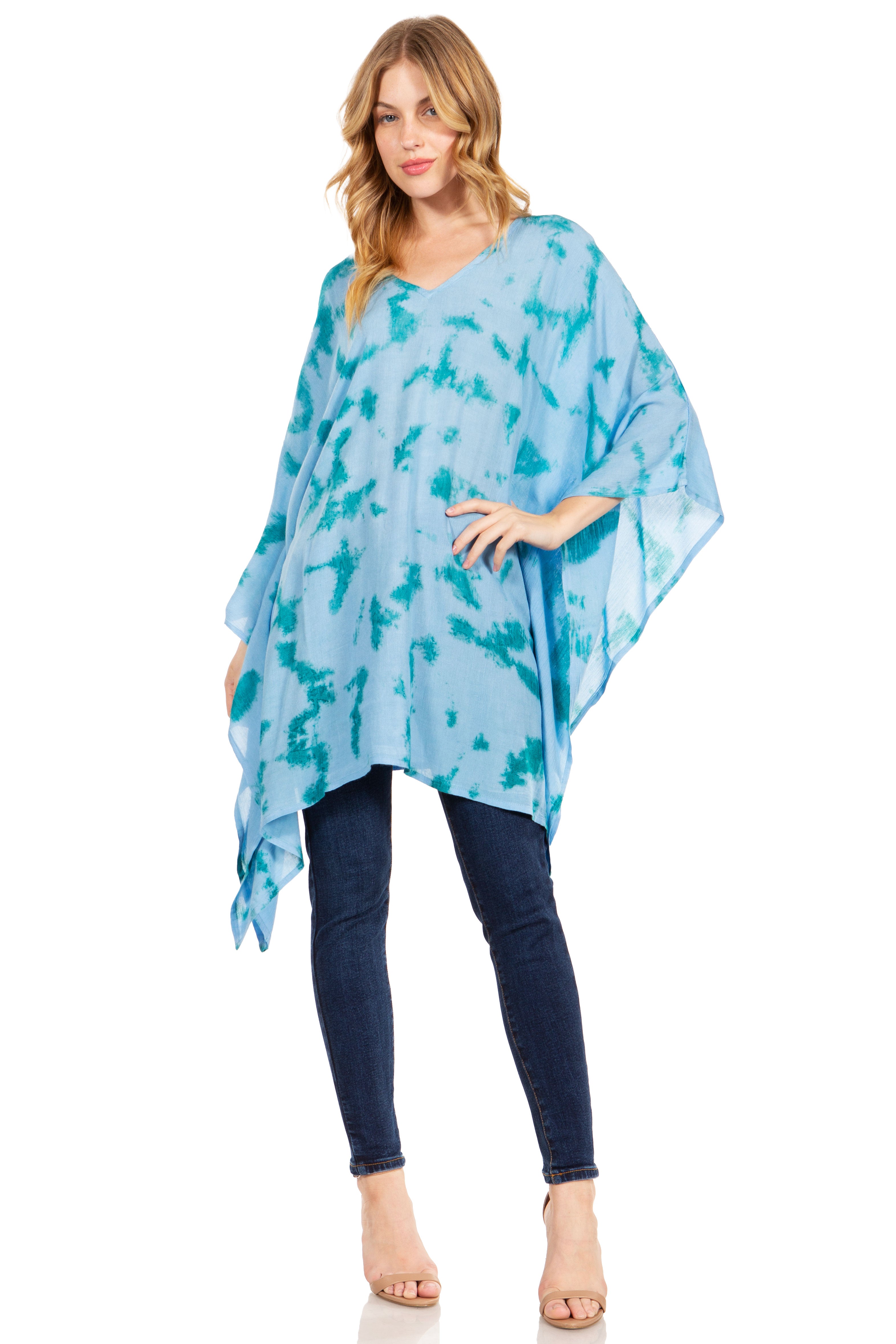 Woman wearing a blue patterned poncho over a white background