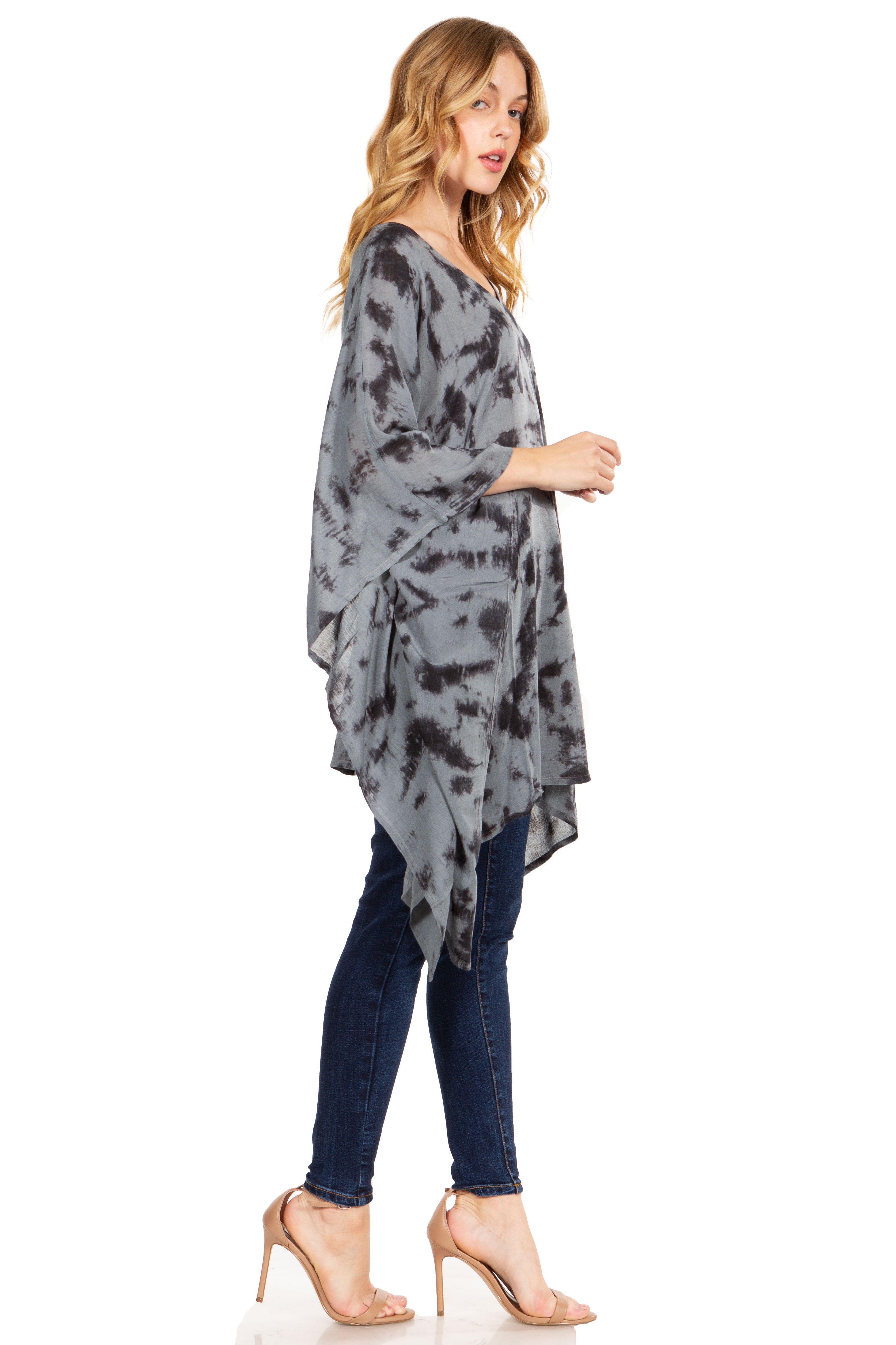 Woman wearing a gray tie-dye poncho over a white background