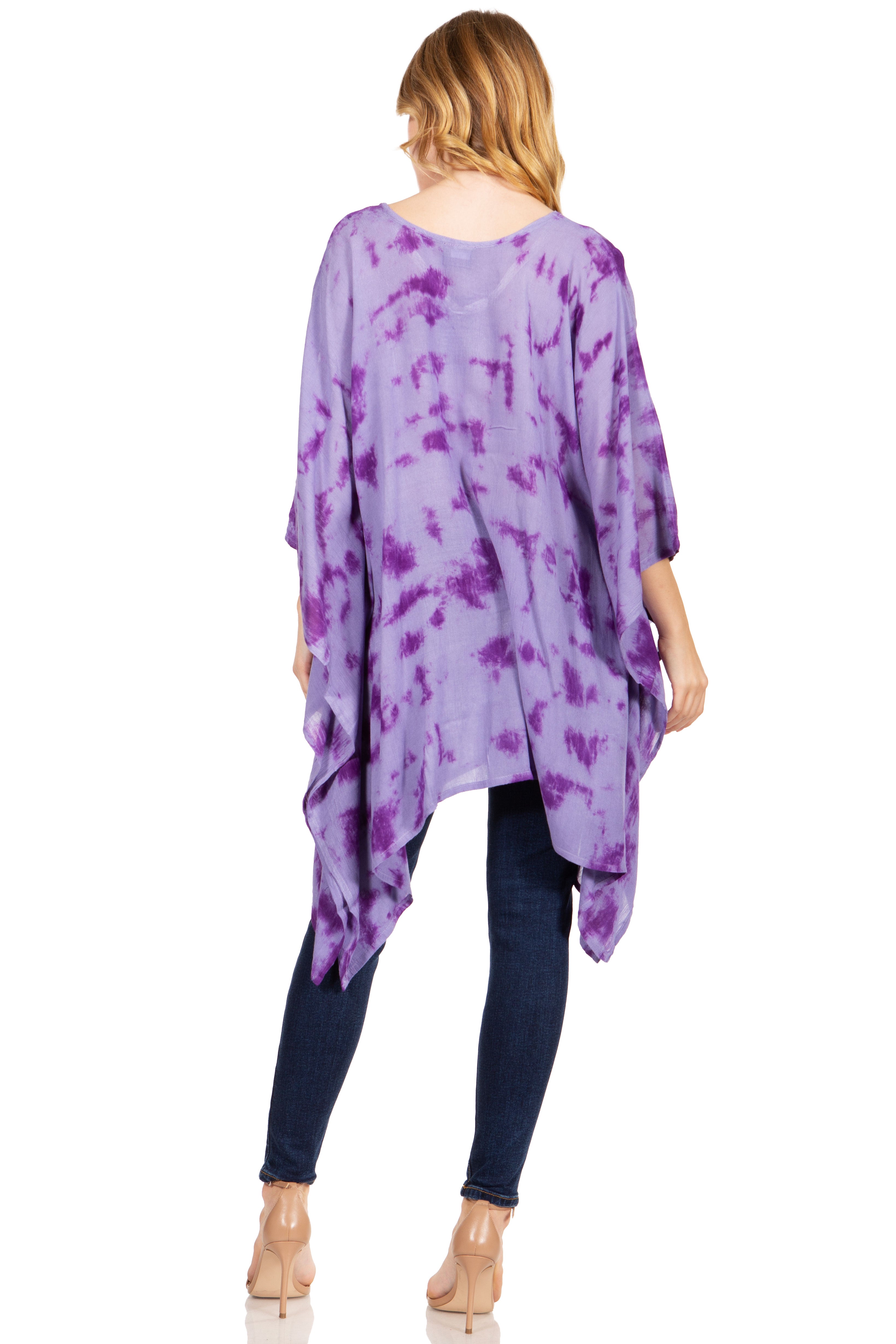 Woman wearing a purple tie-dye poncho over a black outfit on a white background