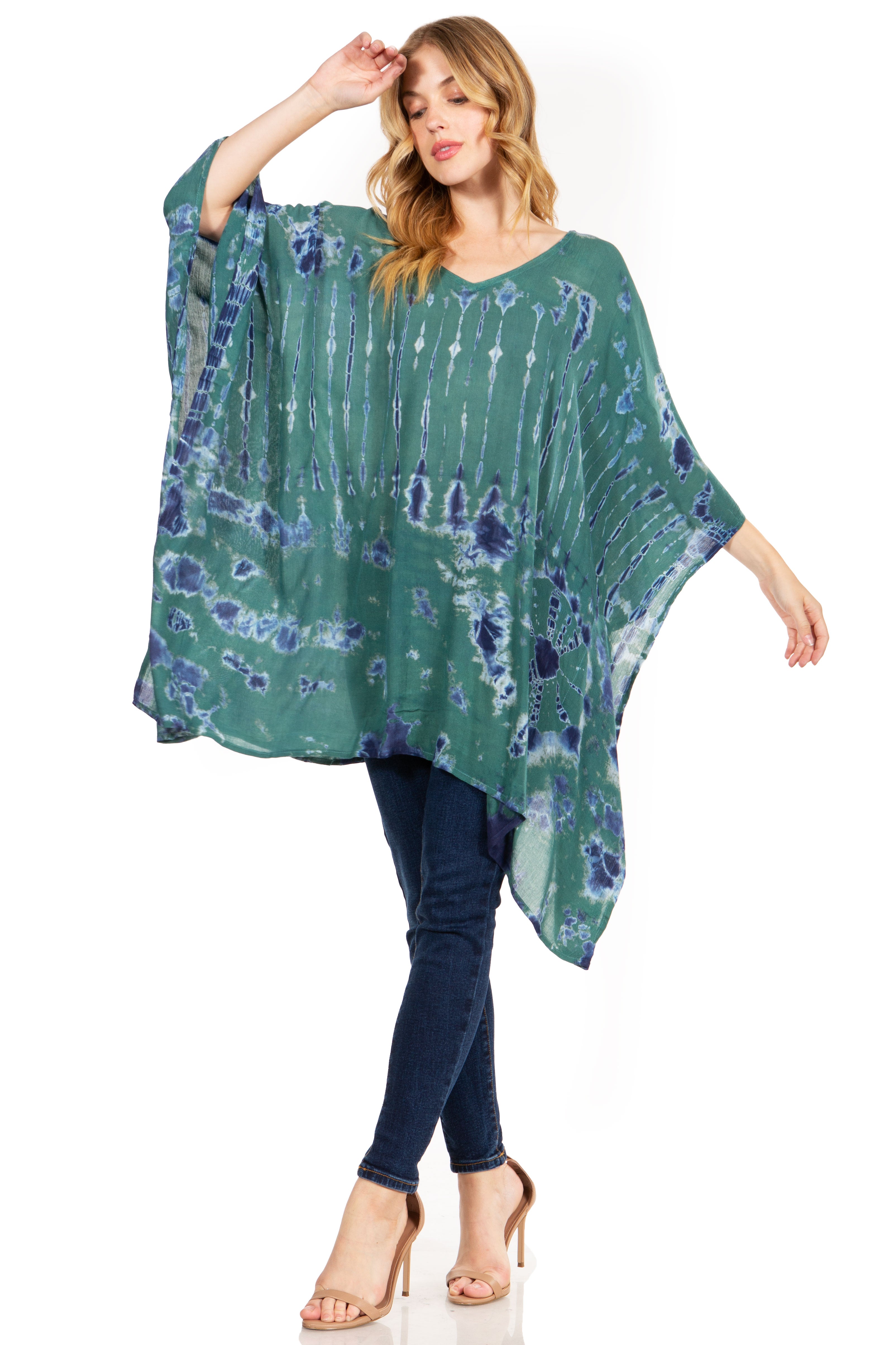 Woman wearing a green tie-dye poncho with blue patterns on a white background