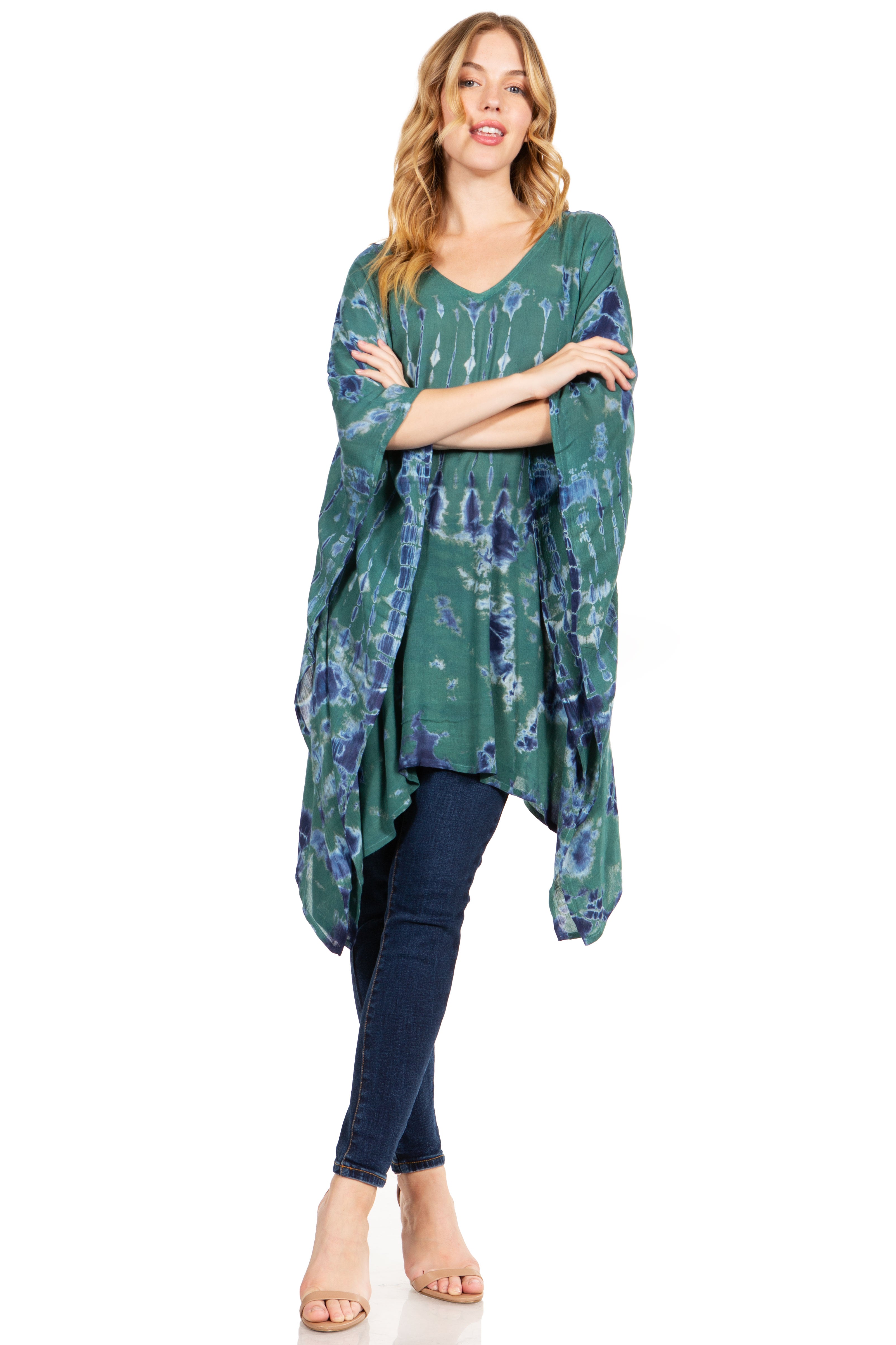 Woman wearing a green floral kimono-style top with blue jeans on a white background