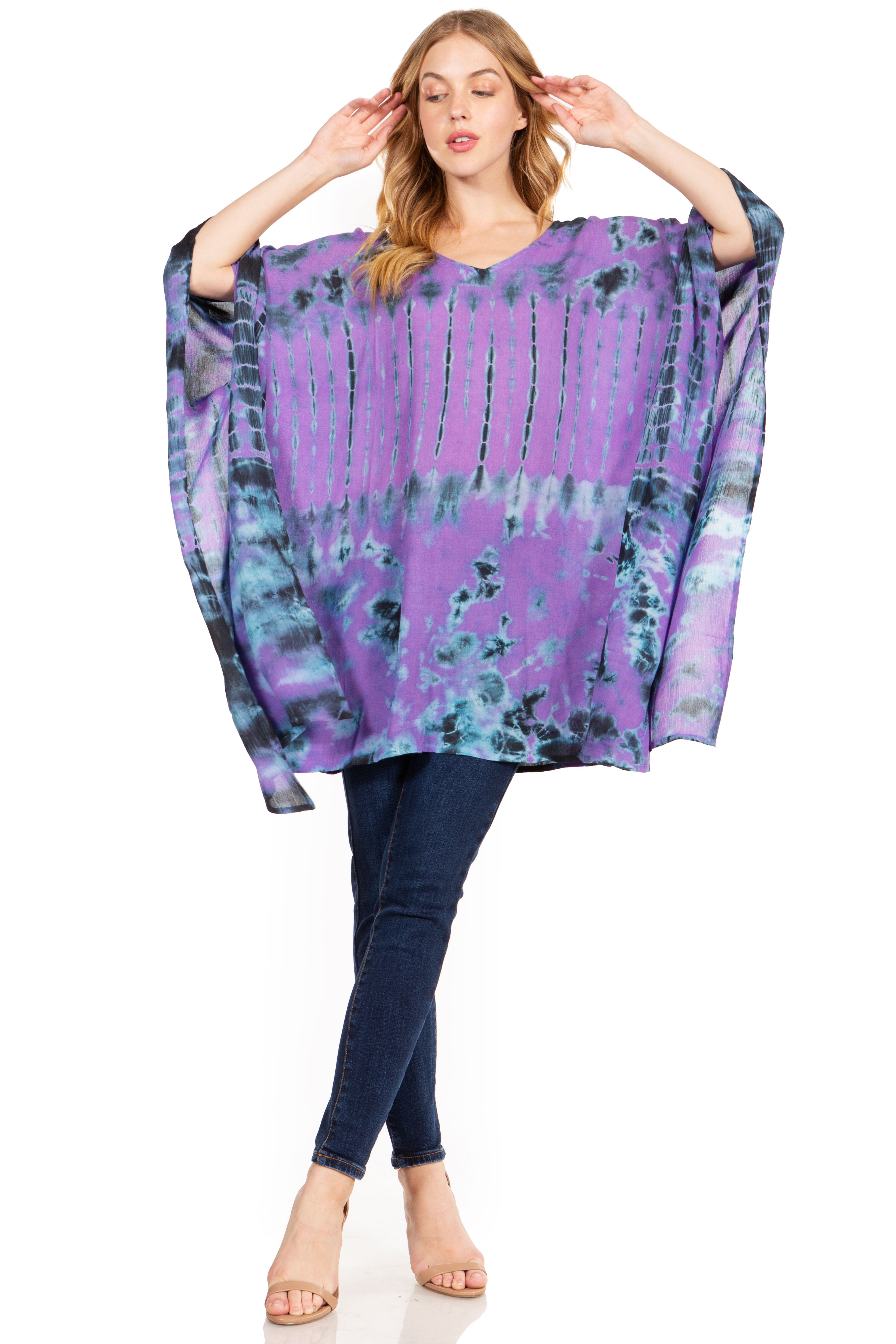 Woman wearing a purple tie-dye poncho over a plain background