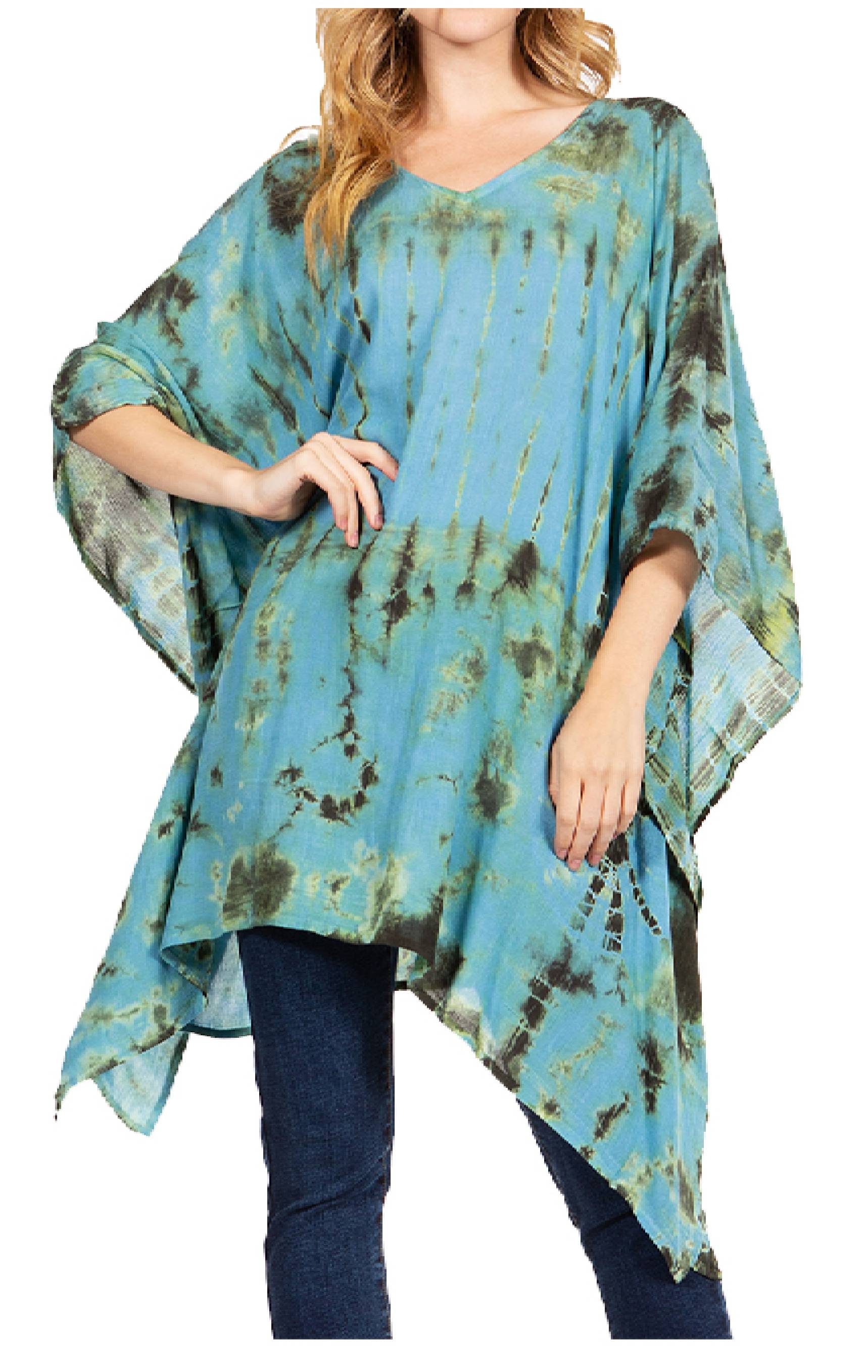 Woman wearing a blue tie-dye poncho over jeans on a white background
