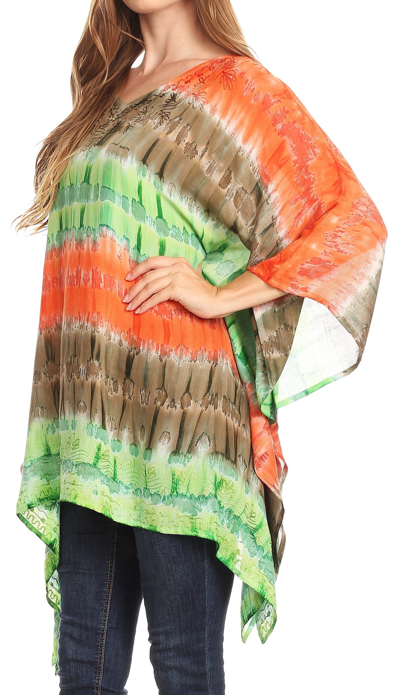 Woman wearing a colorful tie-dye poncho with orange, green, and brown patterns on a white background.