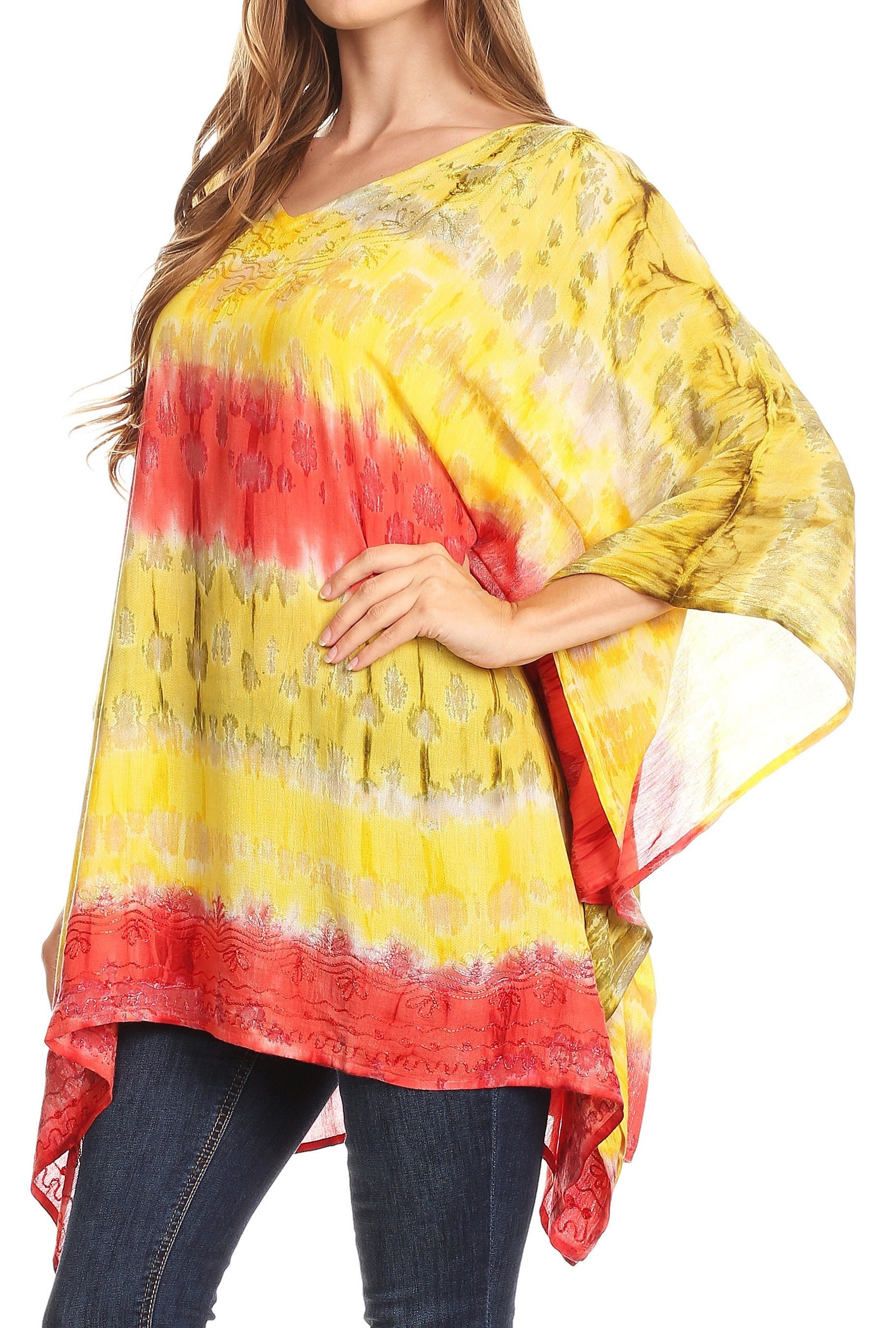 Woman wearing a yellow and red tie-dye top with denim jeans on a white background