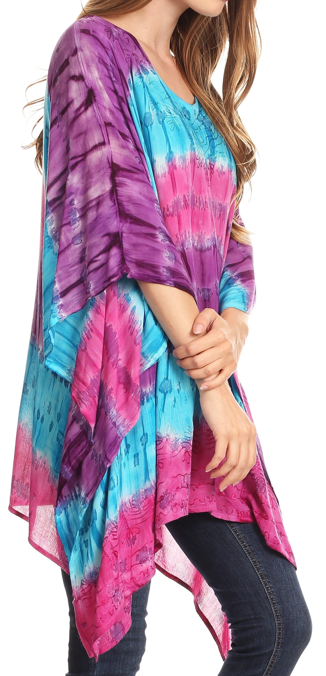 Woman wearing a colorful tie-dye kimono over jeans on a white background