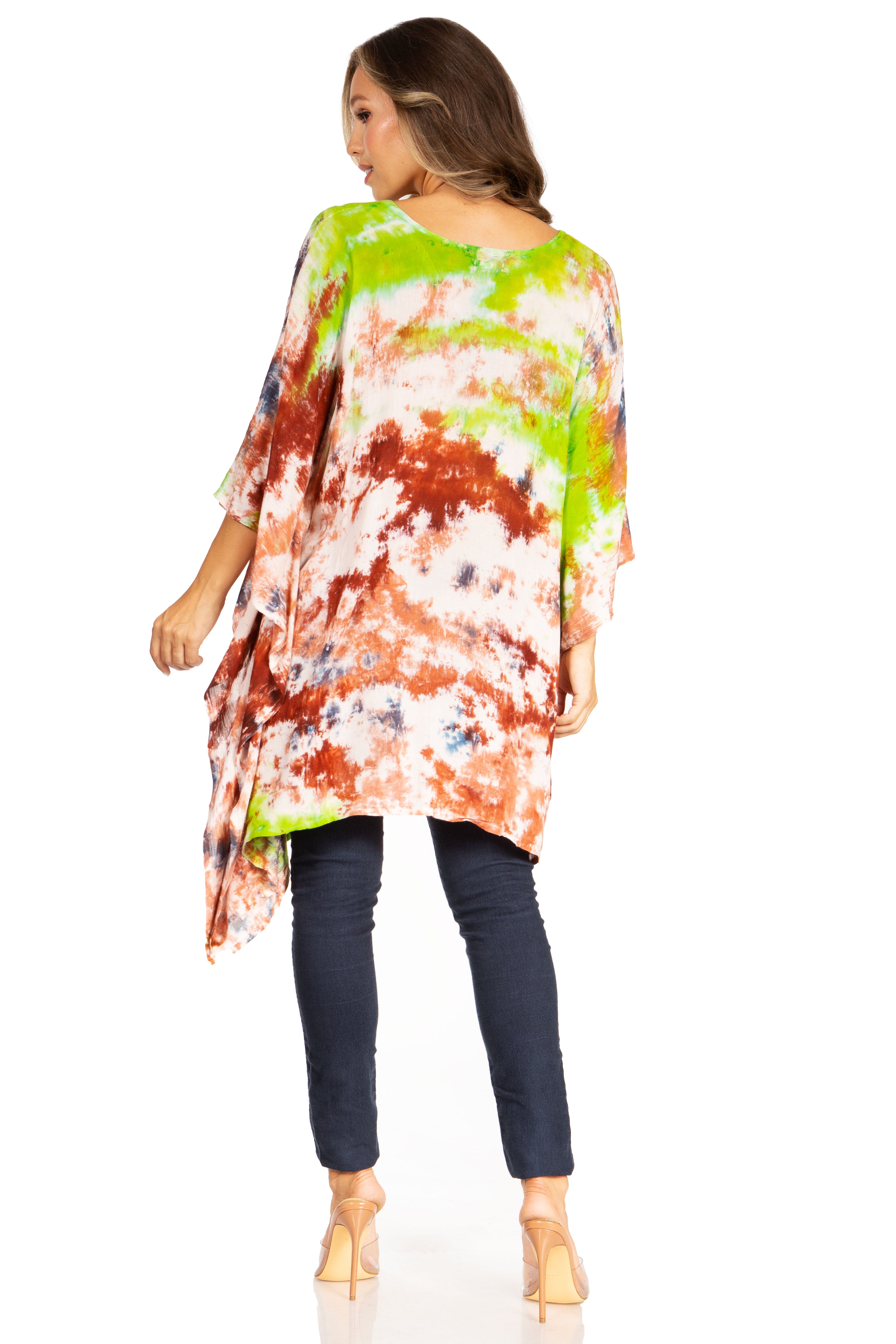 Woman wearing a colorful tie-dye shirt and dark pants on a white background