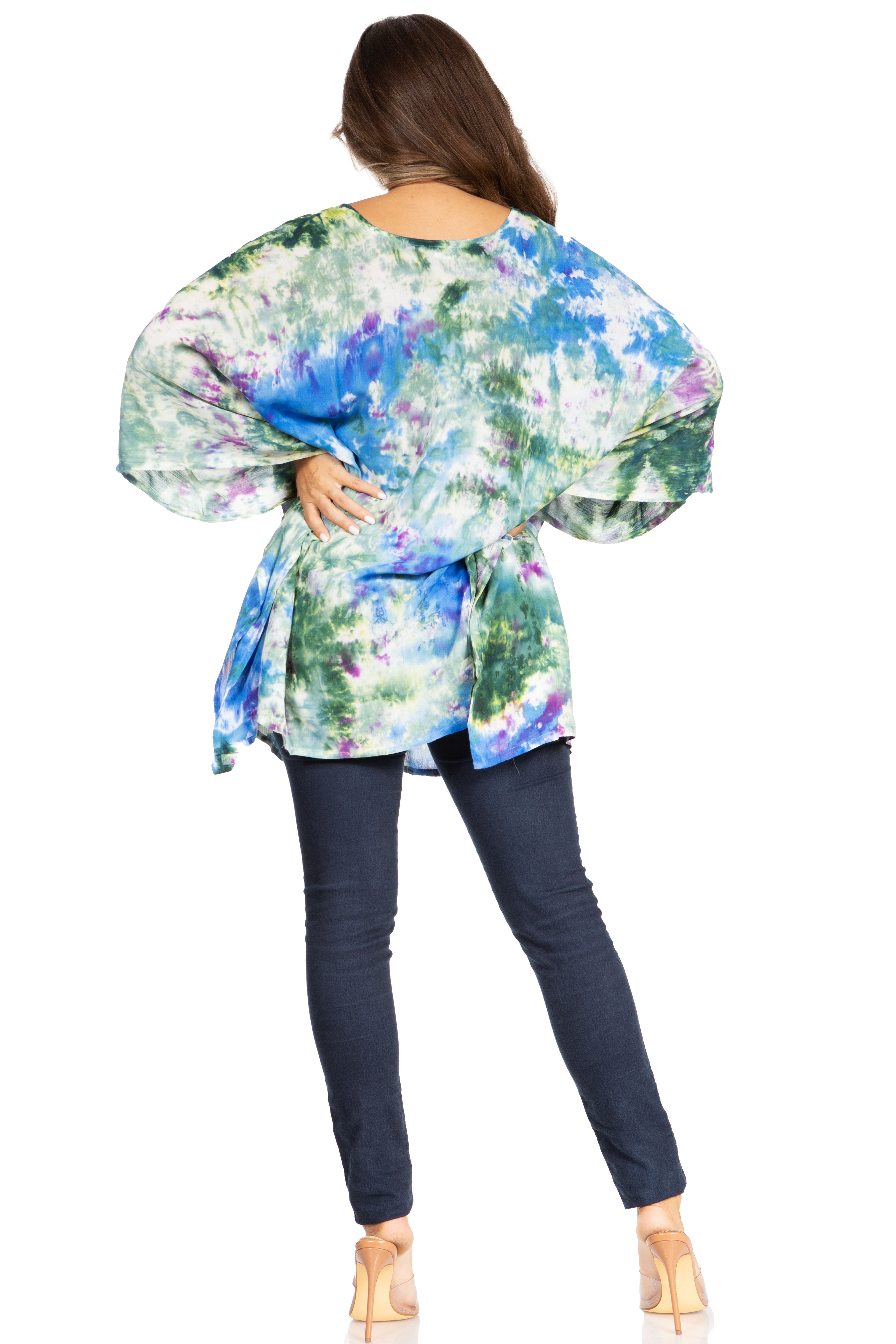 Woman wearing a colorful floral blouse and dark pants on a white background