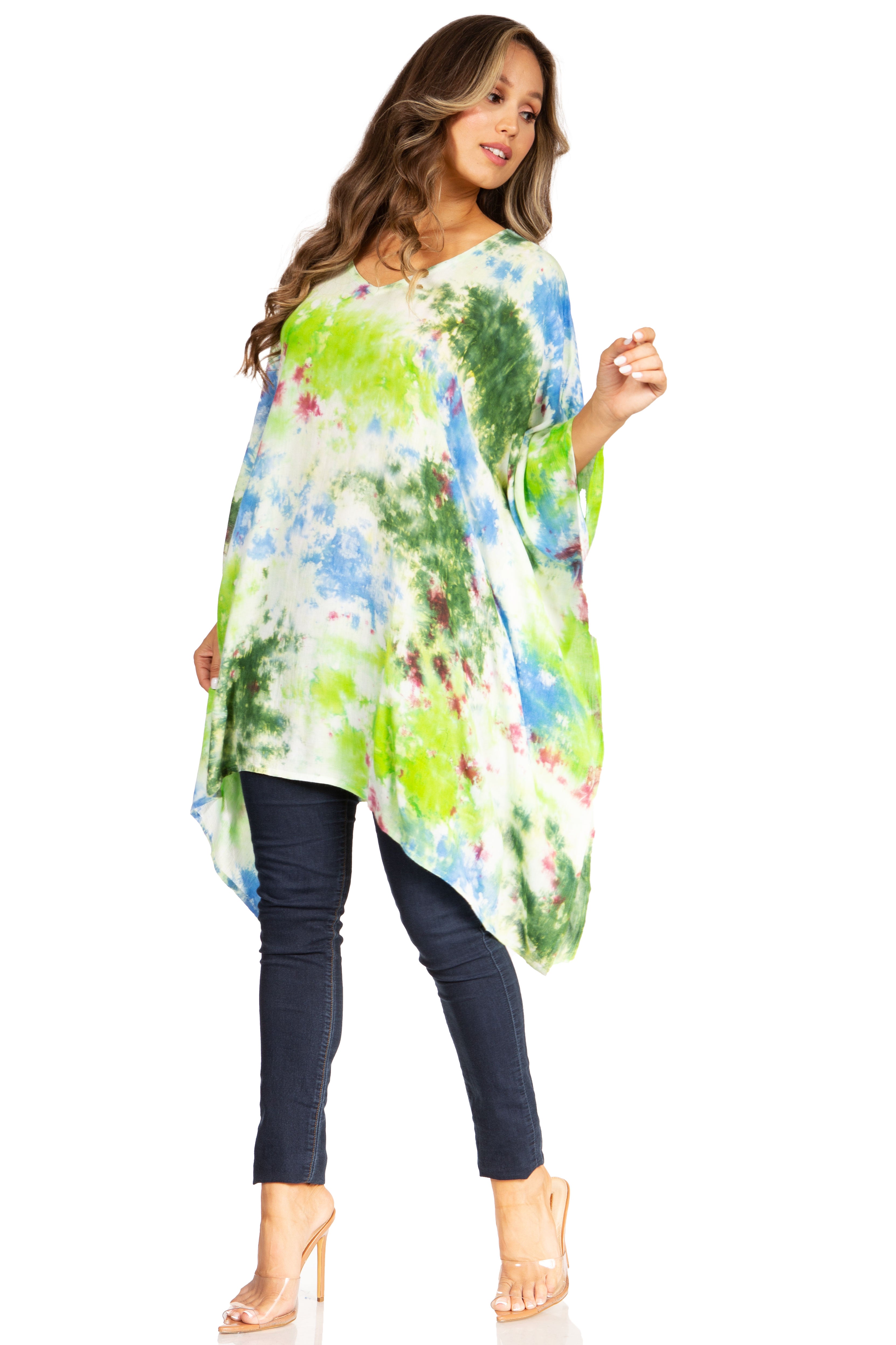 Woman wearing a colorful floral tunic over dark jeans on a white background