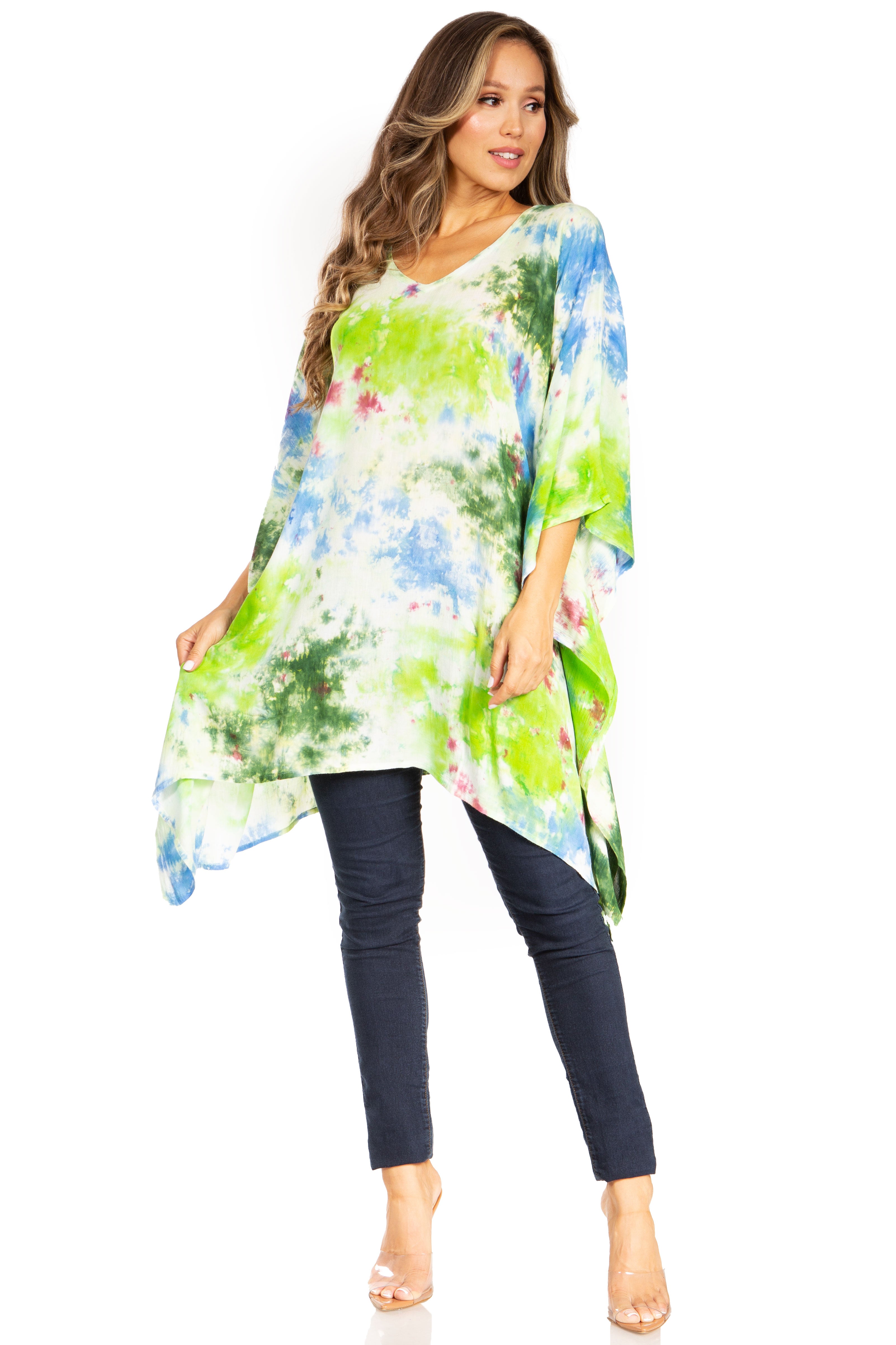 Woman wearing a colorful tie-dye tunic and dark pants on a white background