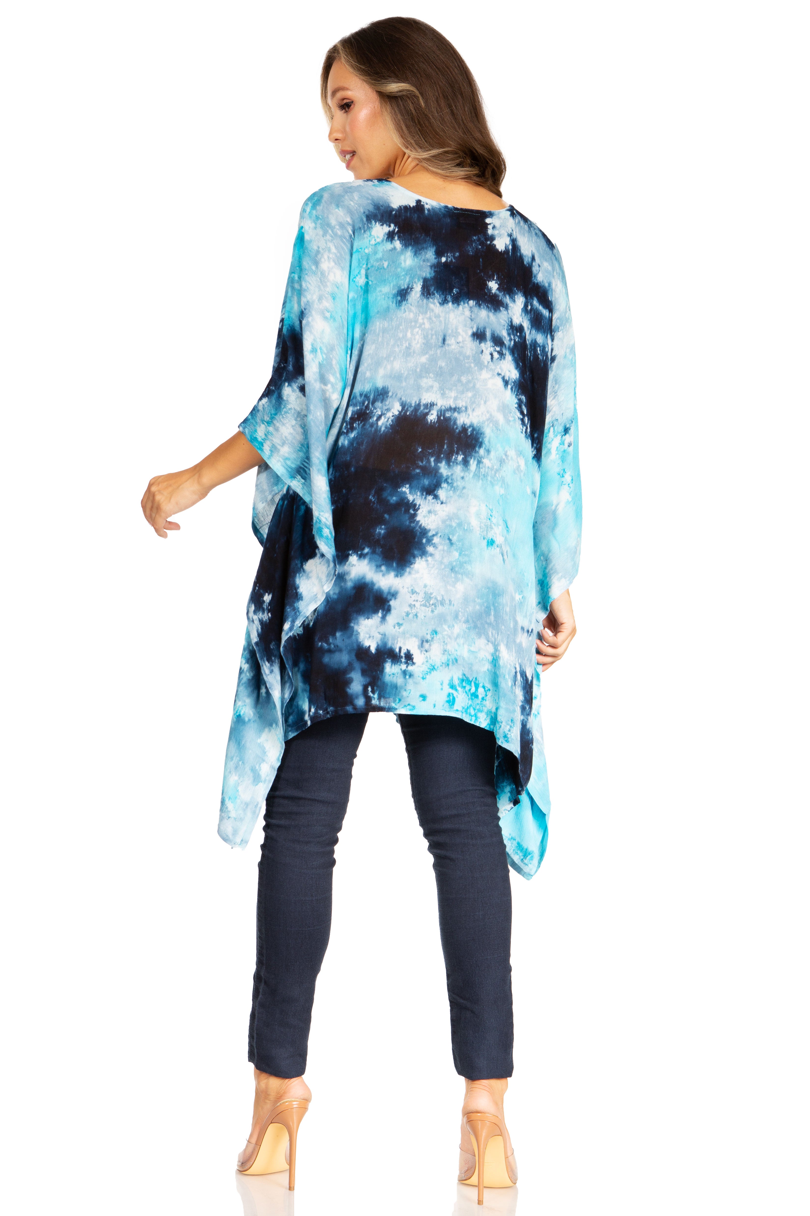 Woman wearing a blue tie-dye top and dark pants on a white background