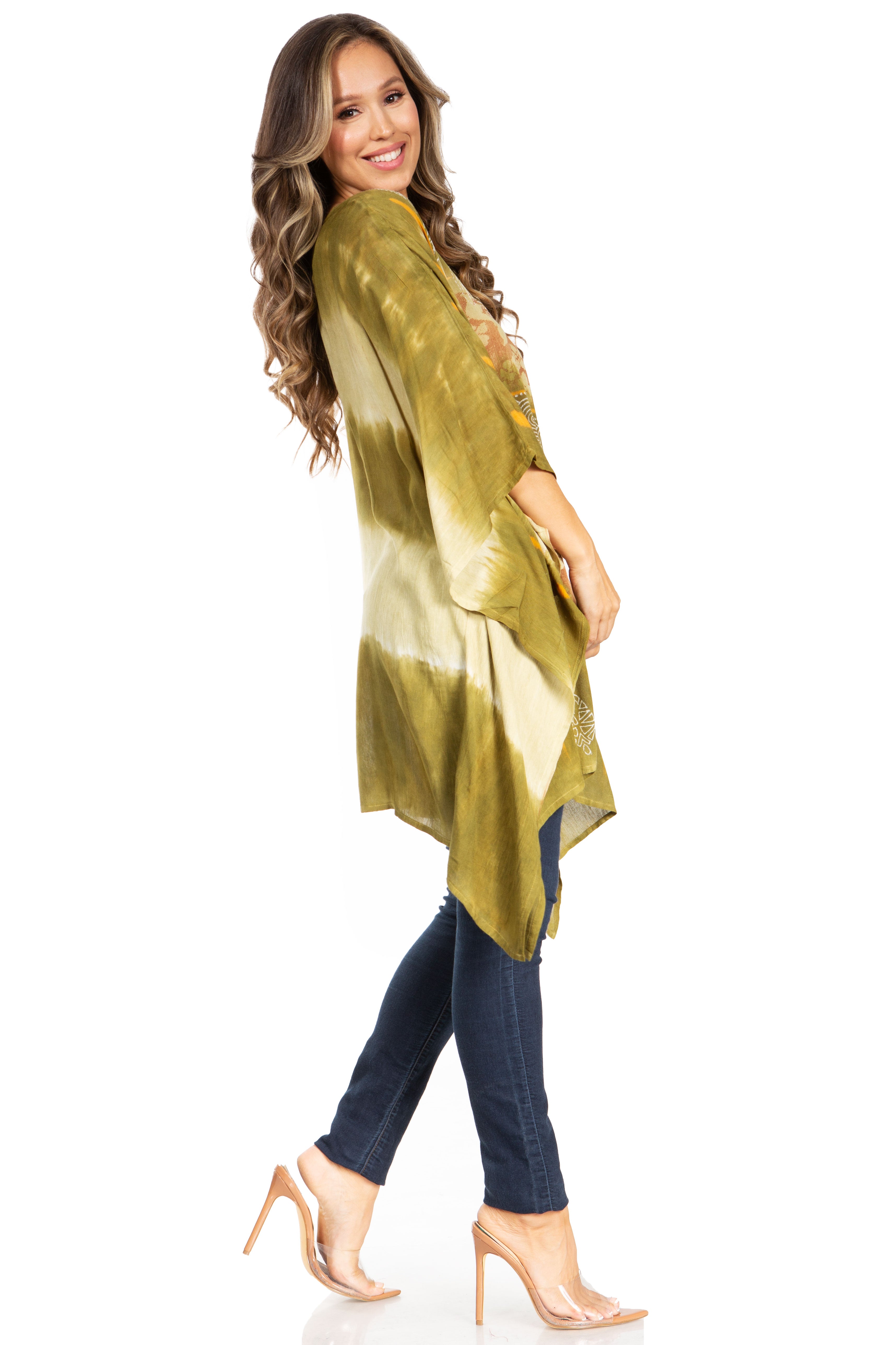 Woman wearing a green tie-dye shirt and dark jeans on a white background