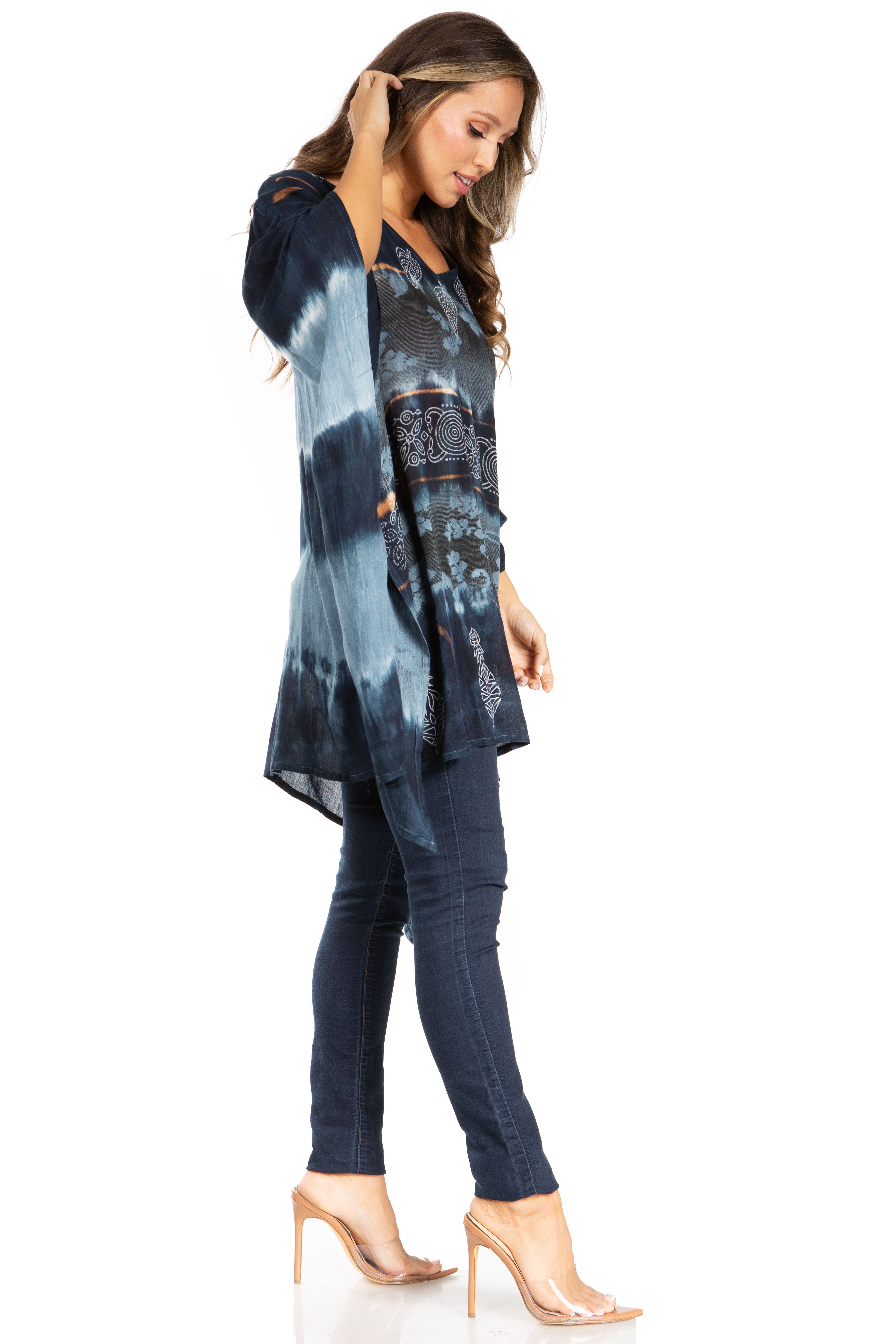 Woman wearing a tie-dye shirt and jeans on a white background