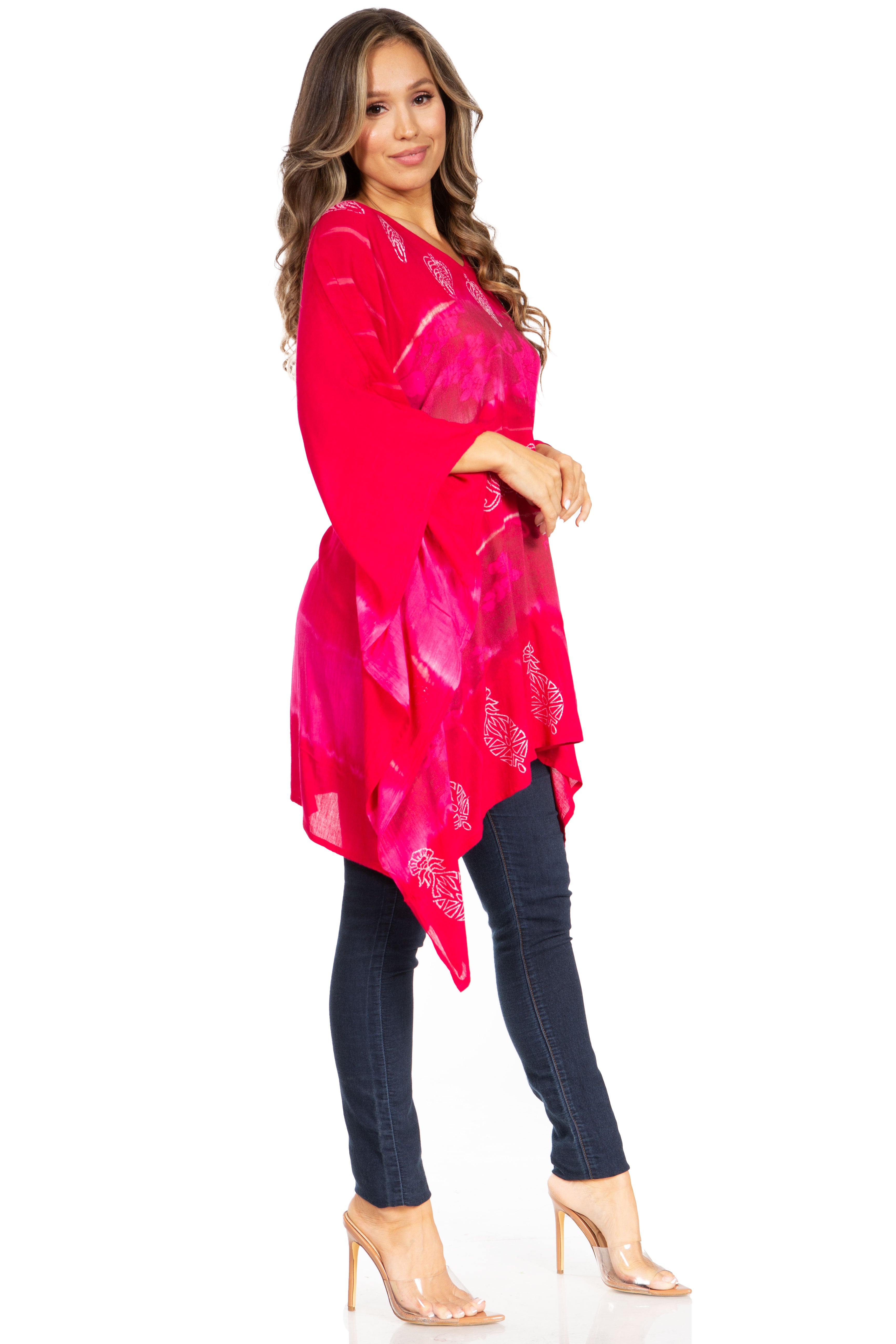 Woman wearing a bright pink kimono-style top and dark jeans on a white background