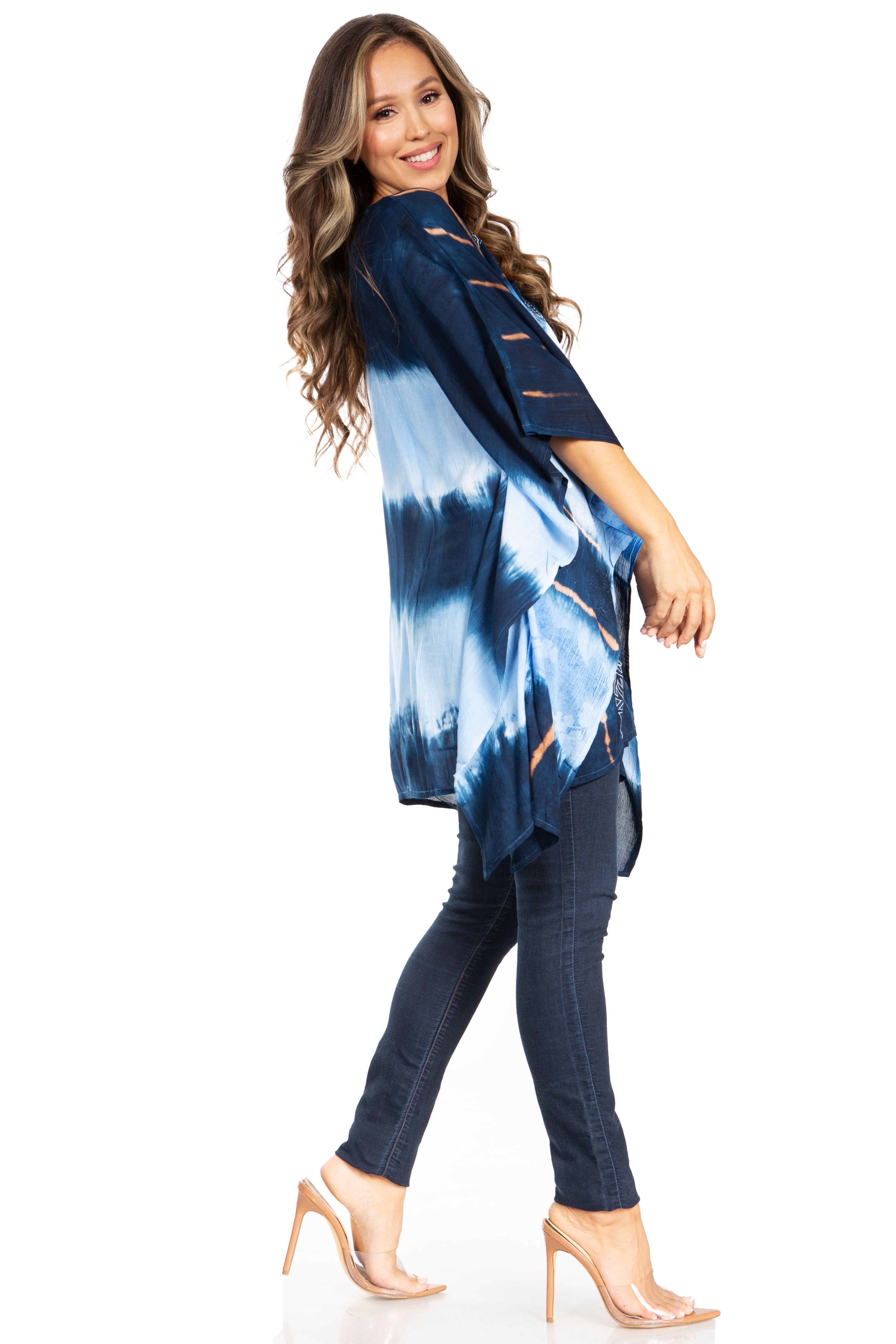 Woman wearing a blue tie-dye top and dark pants on a white background