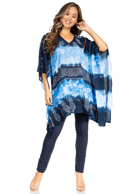 Woman wearing a blue and navy patterned poncho over a matching outfit on a white background