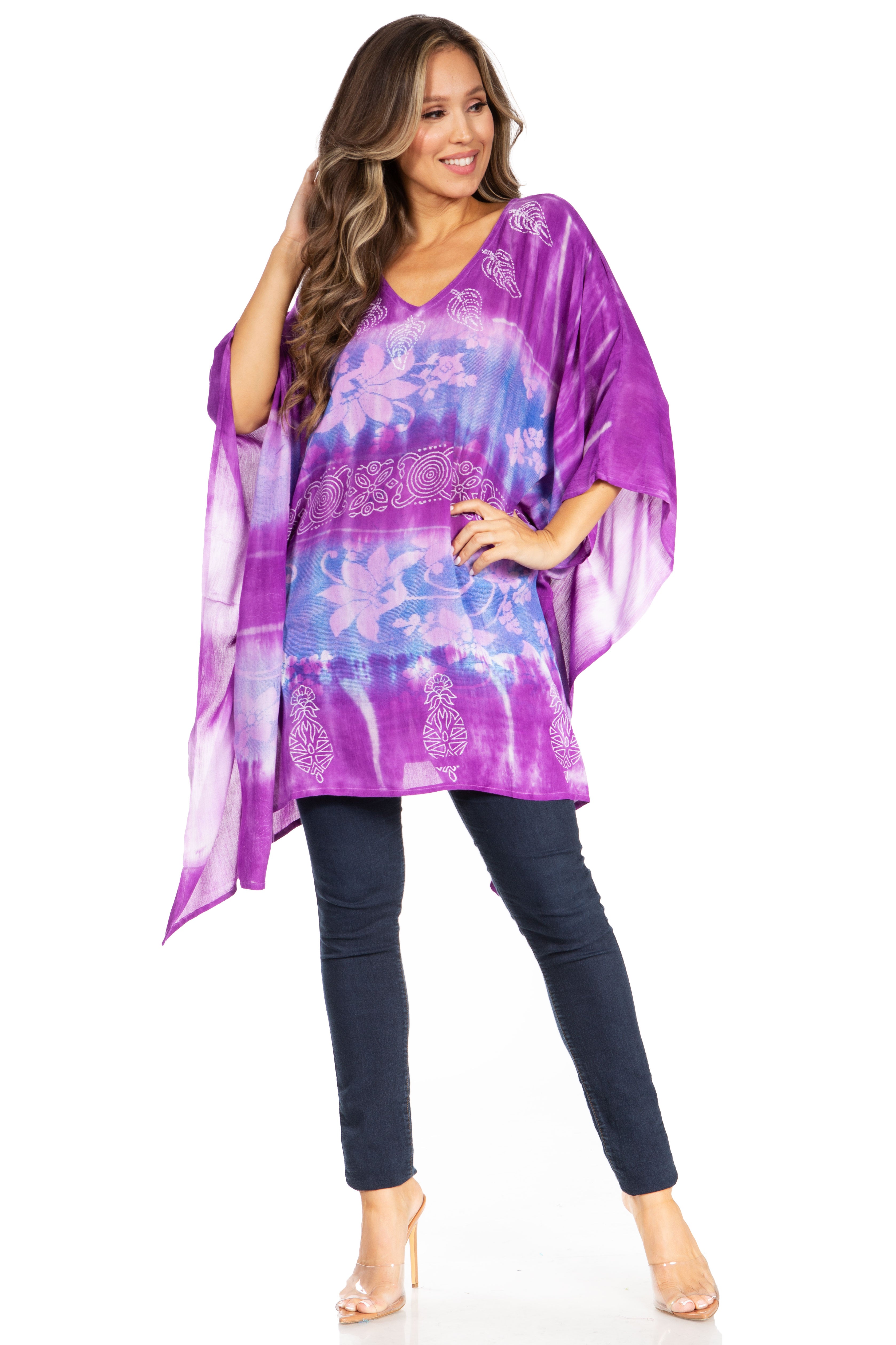 Woman wearing a purple tie-dye top and dark jeans on a white background