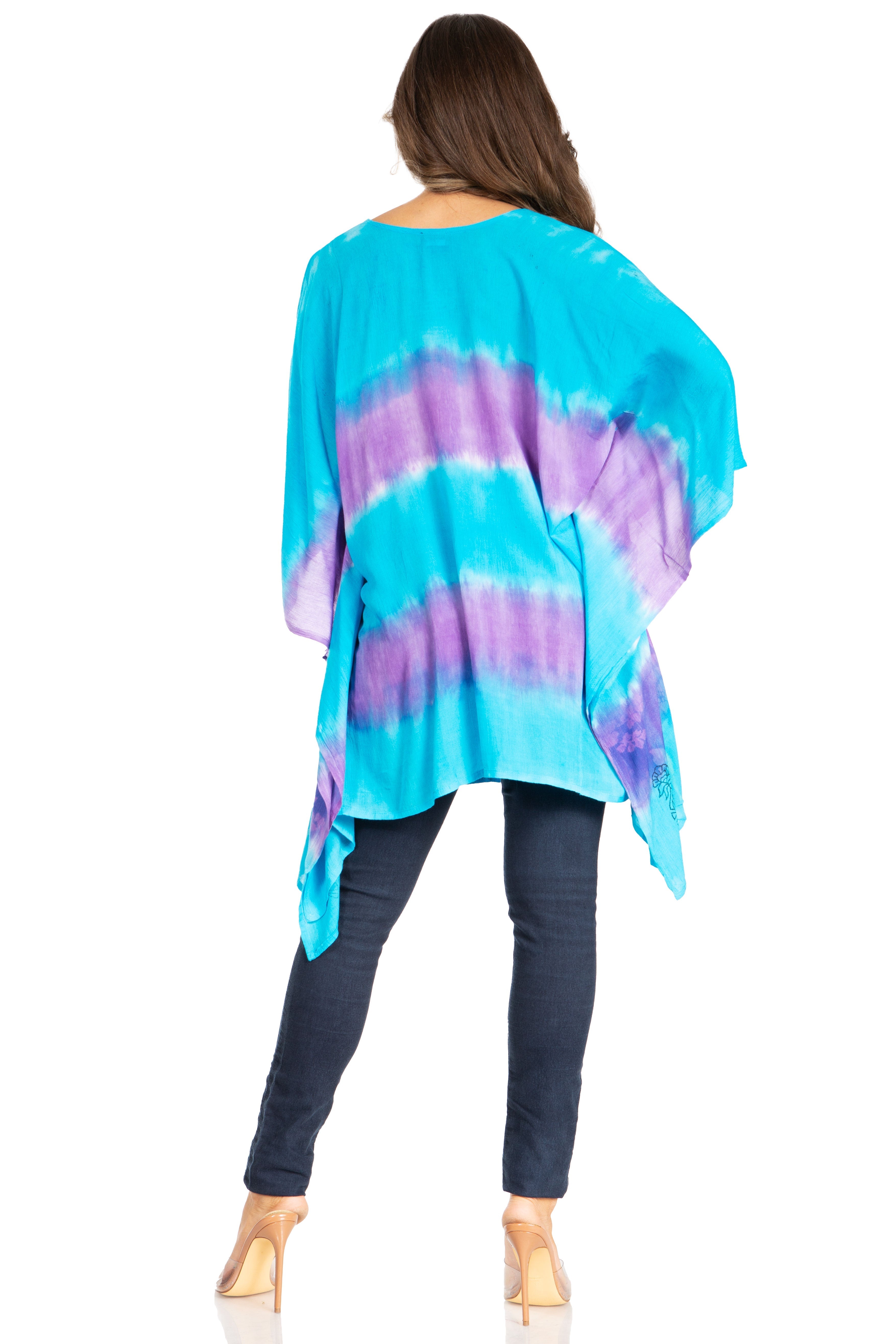 Woman wearing a tie-dye shirt and dark pants on a white background