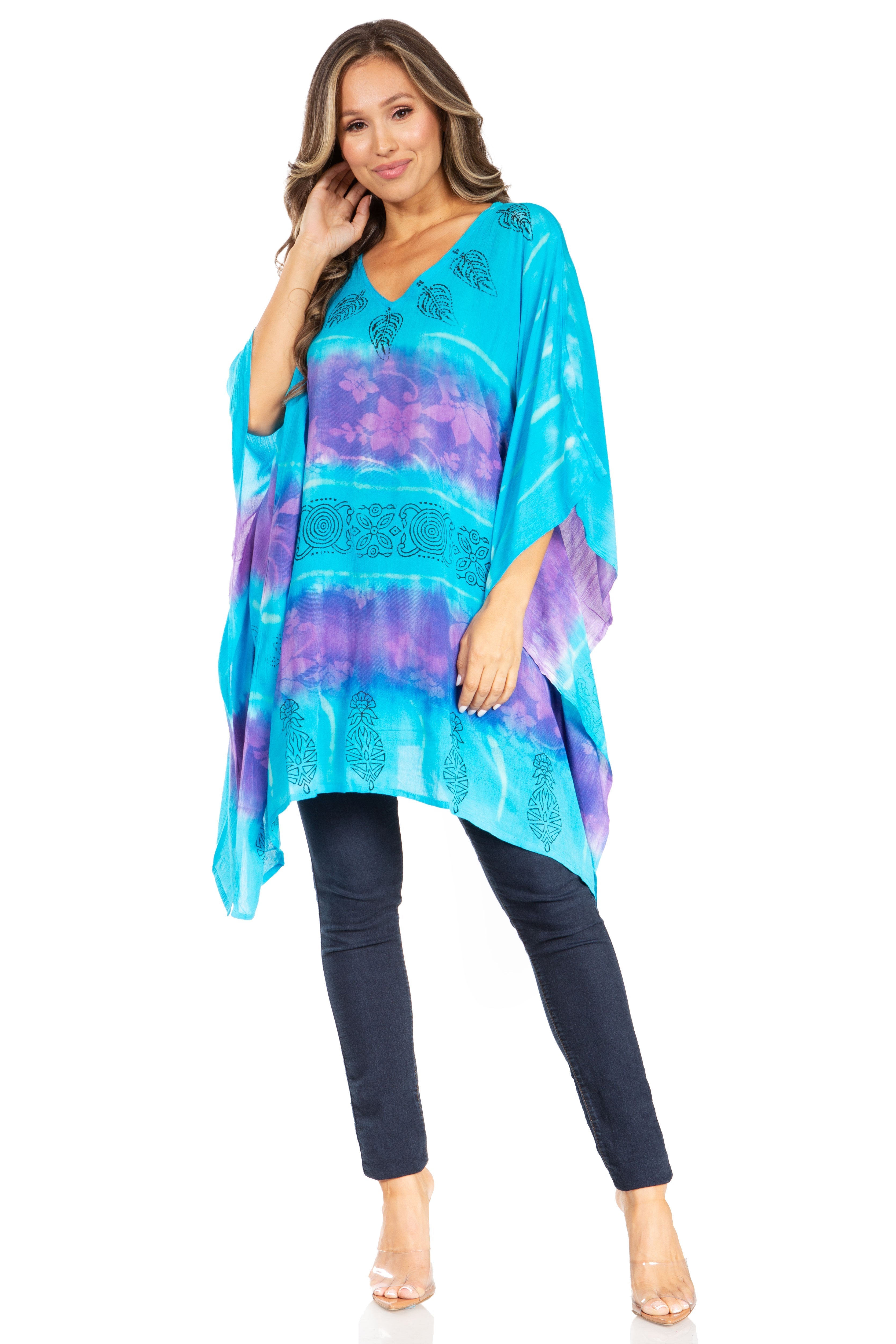 Woman wearing a colorful tie-dye top and black pants on a white background
