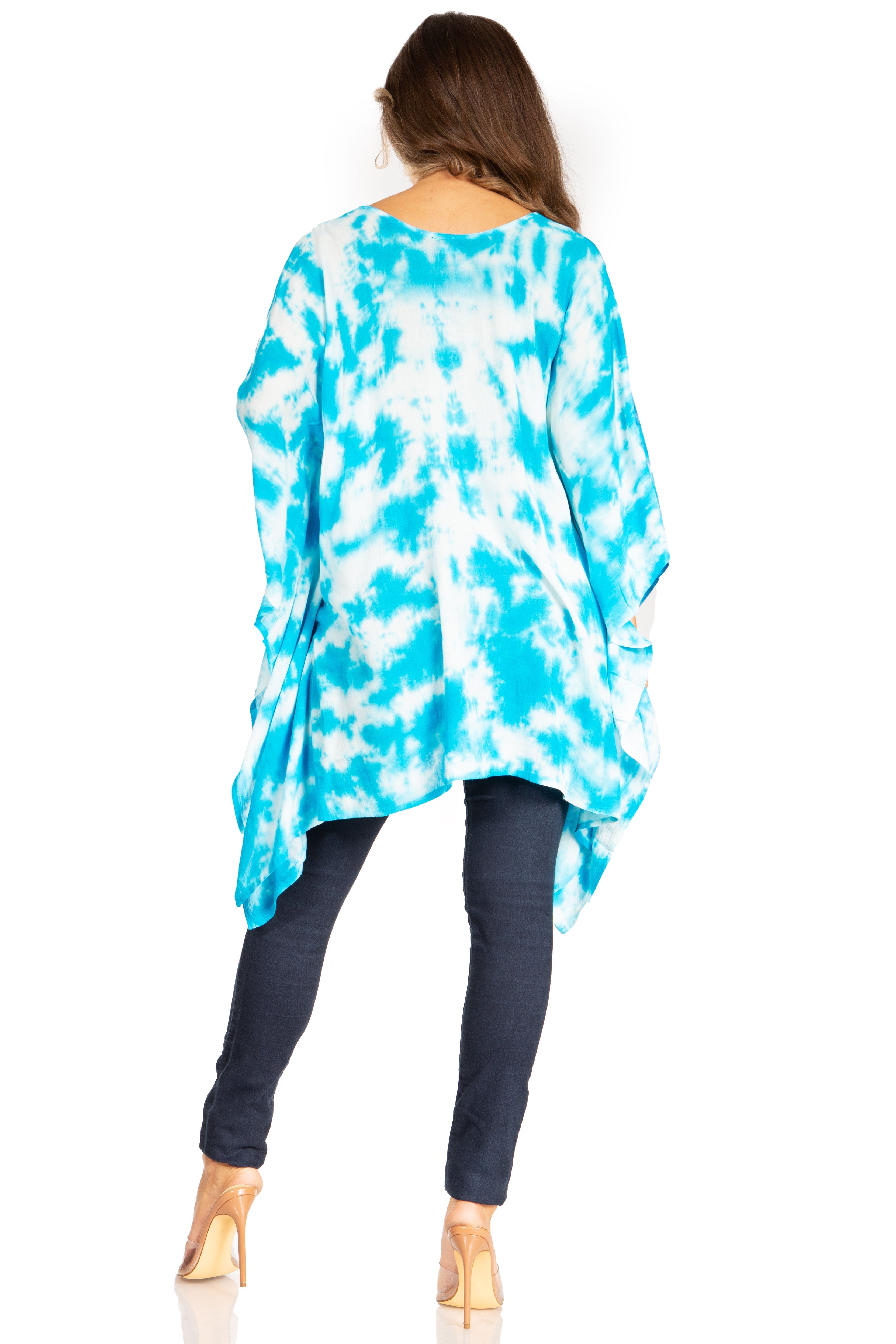 Woman wearing a blue and white tie-dye top with dark jeans on a white background