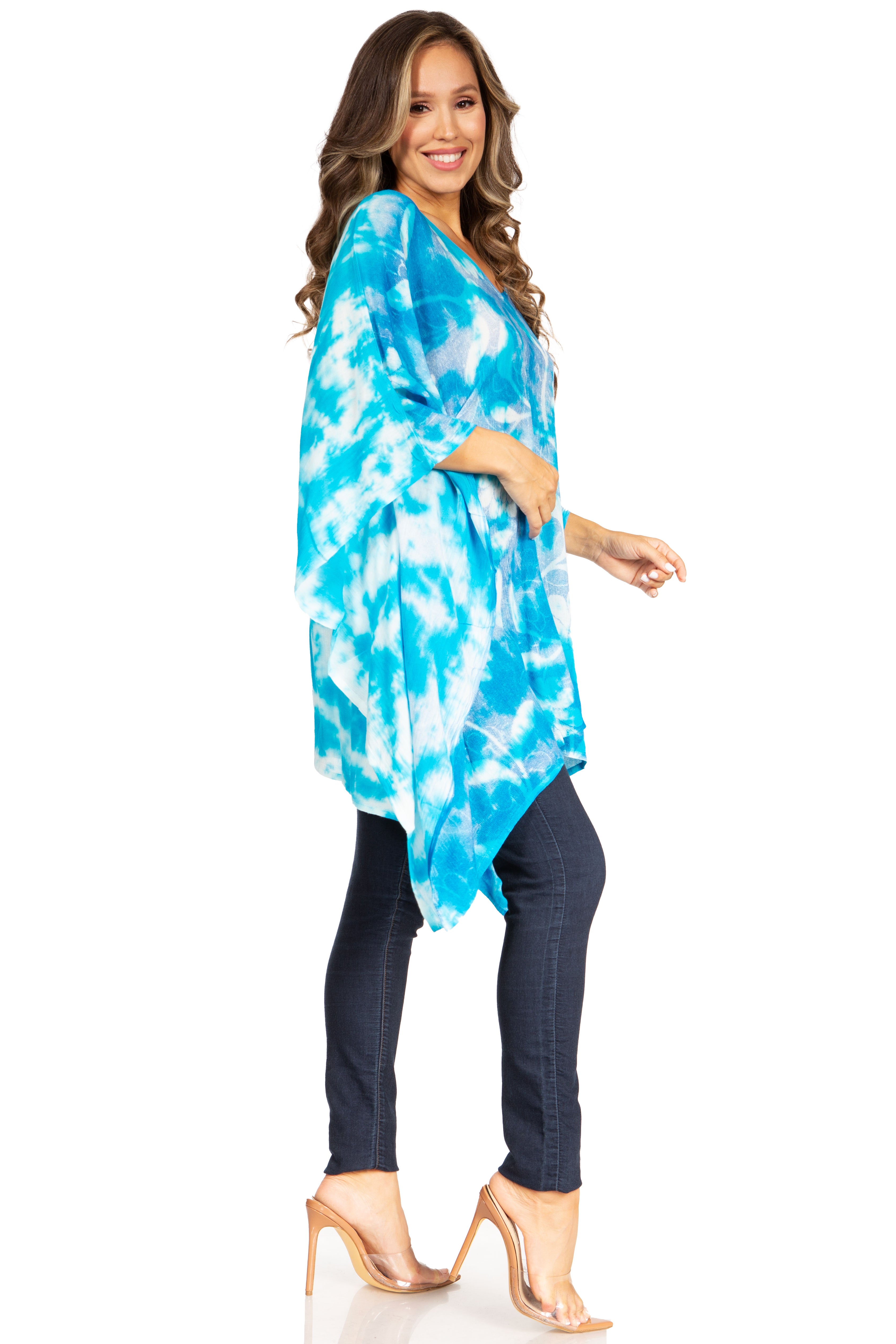 Woman wearing a blue tie-dye top and dark pants on a white background