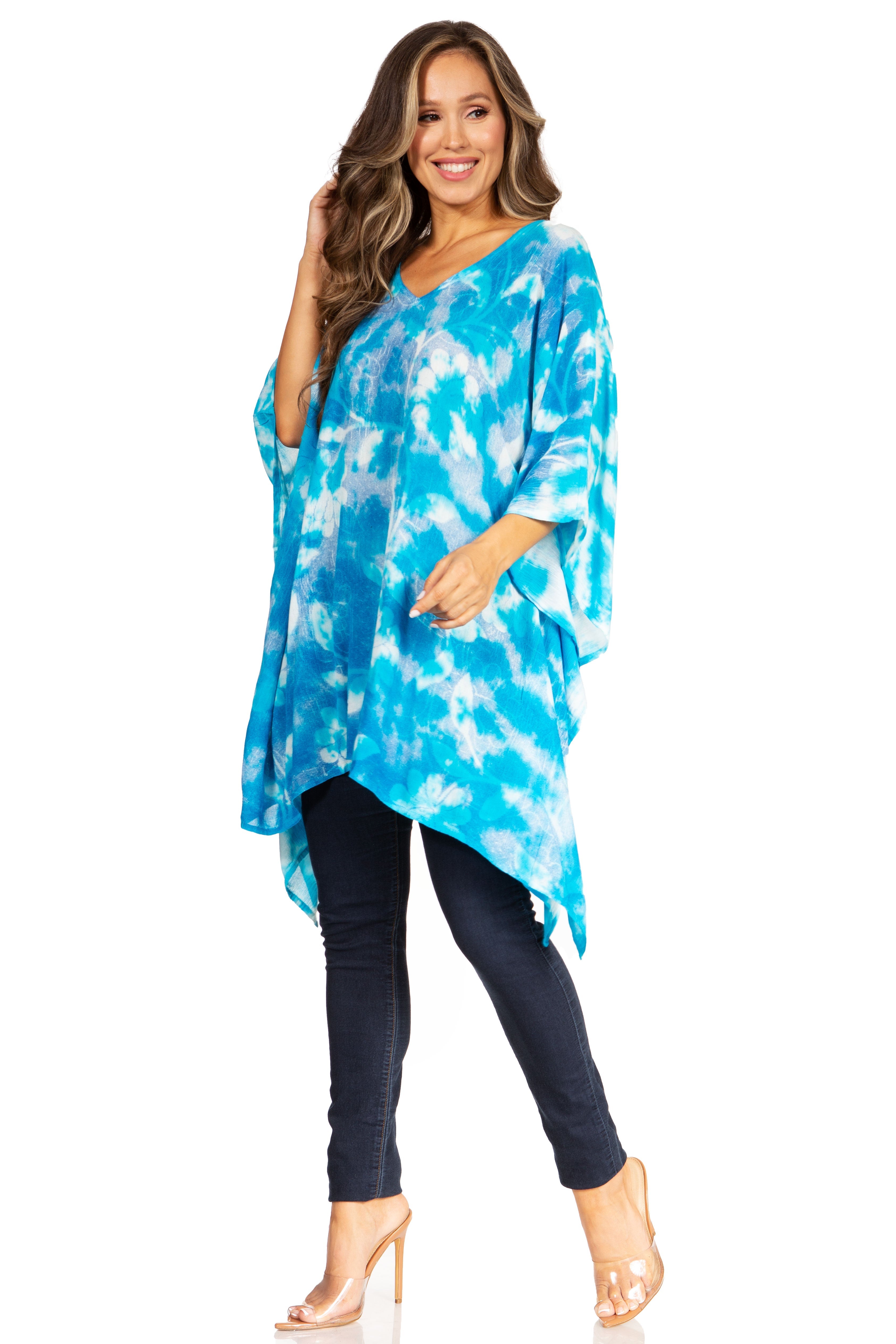 Woman wearing a blue tie-dye top and black pants on a white background