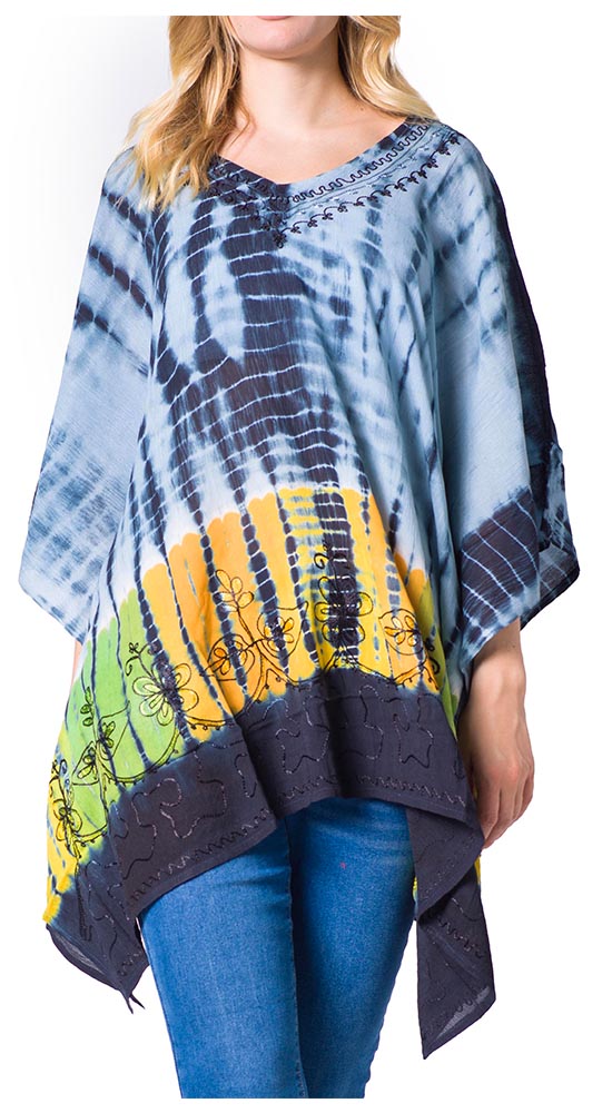 Person wearing a colorful tie-dye poncho with blue jeans on a white background