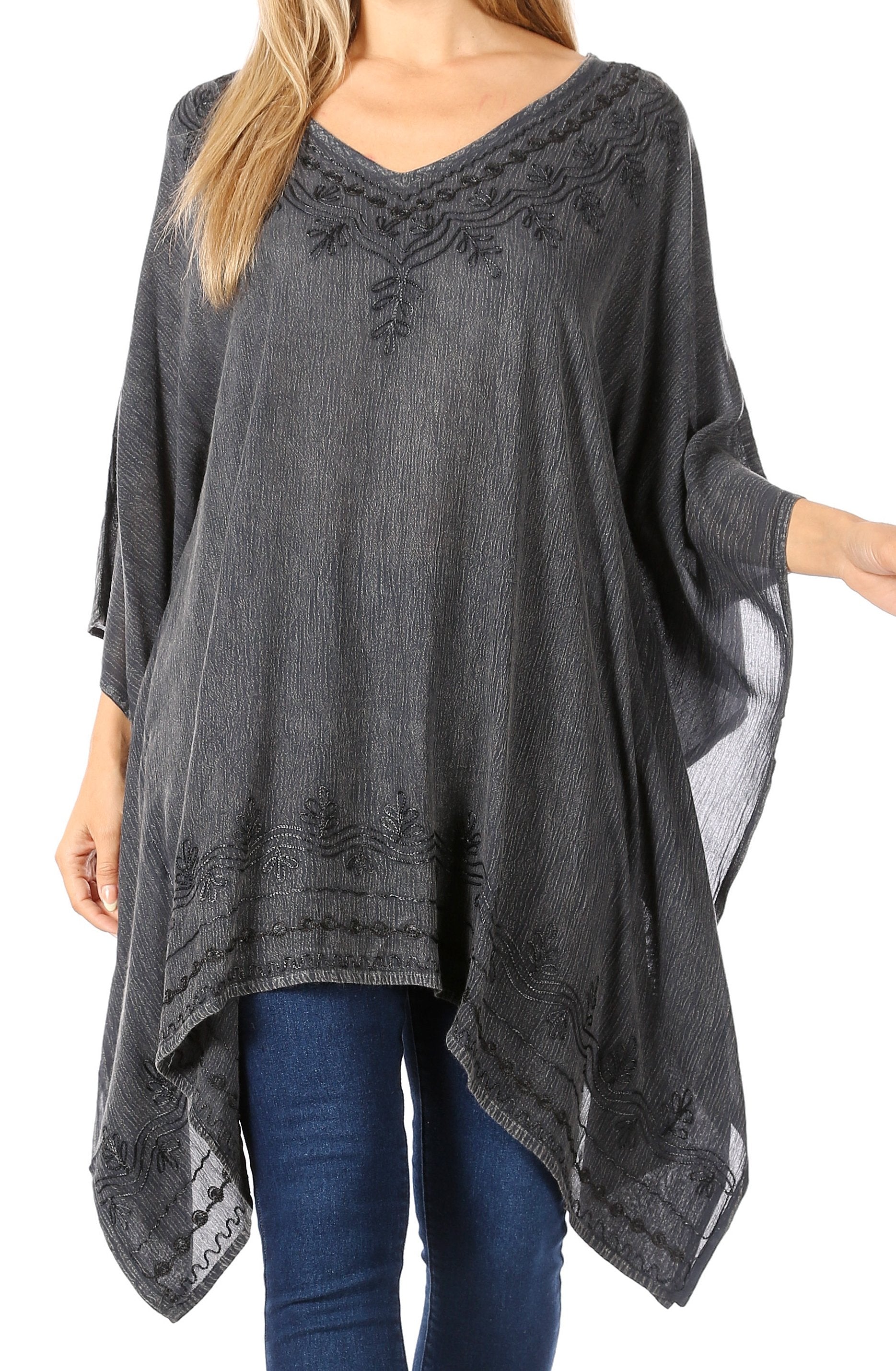 Gray poncho with lace details worn by a person on a white background