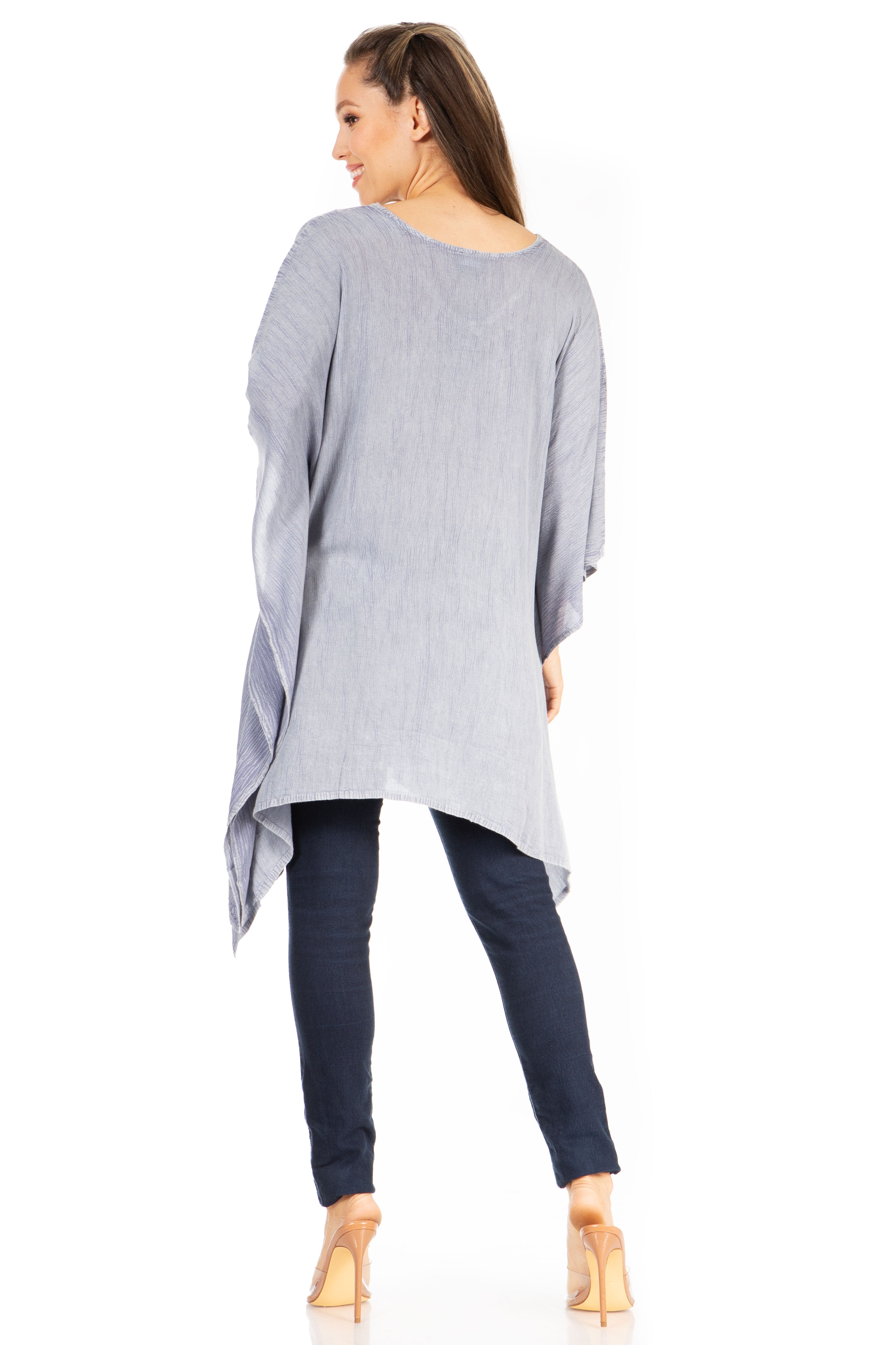 Woman wearing a gray oversized top and dark pants on a white background
